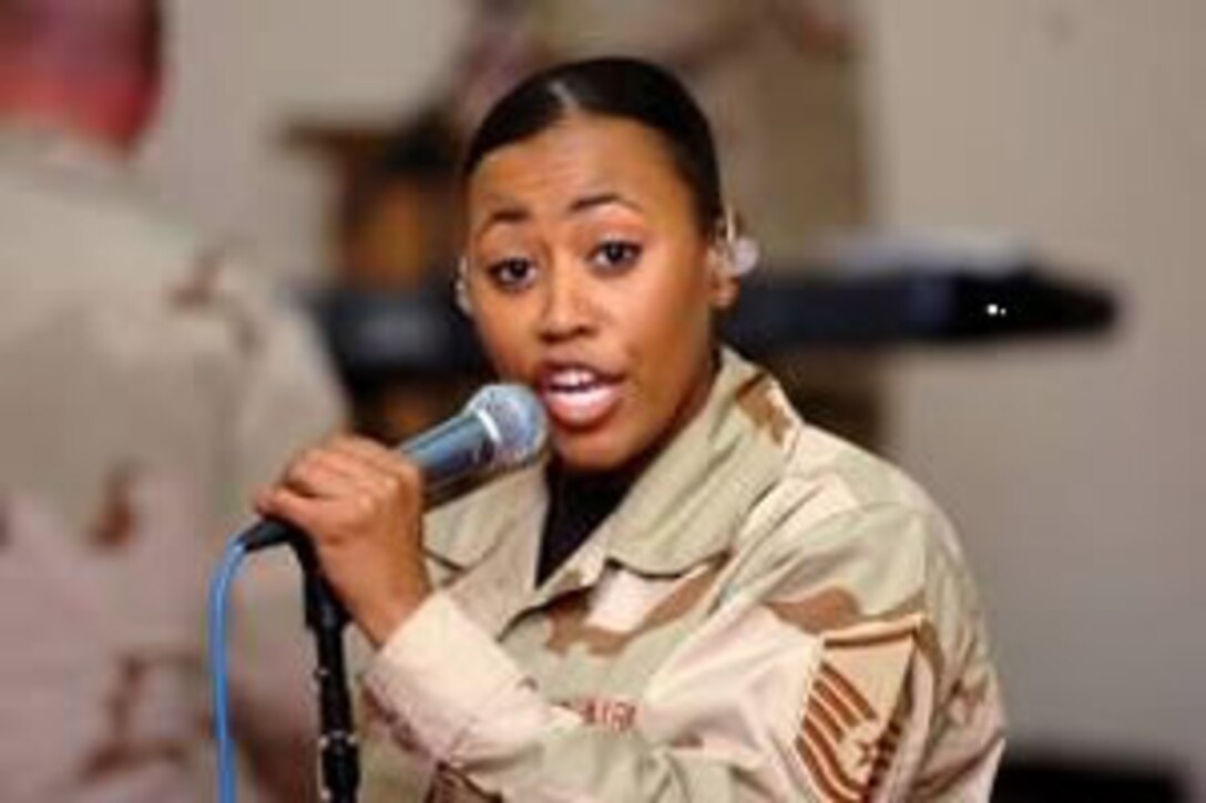 Air Force Master Sgt. Regina Coonrod, one of Max Impact's vocalists, gets the night started with her version of the Black Eyed Peas. The band performed at the Camp Taji movie theater March 8. (U.S. Army Photo by Spc. Karly Cooper, 15th SB PAO)
