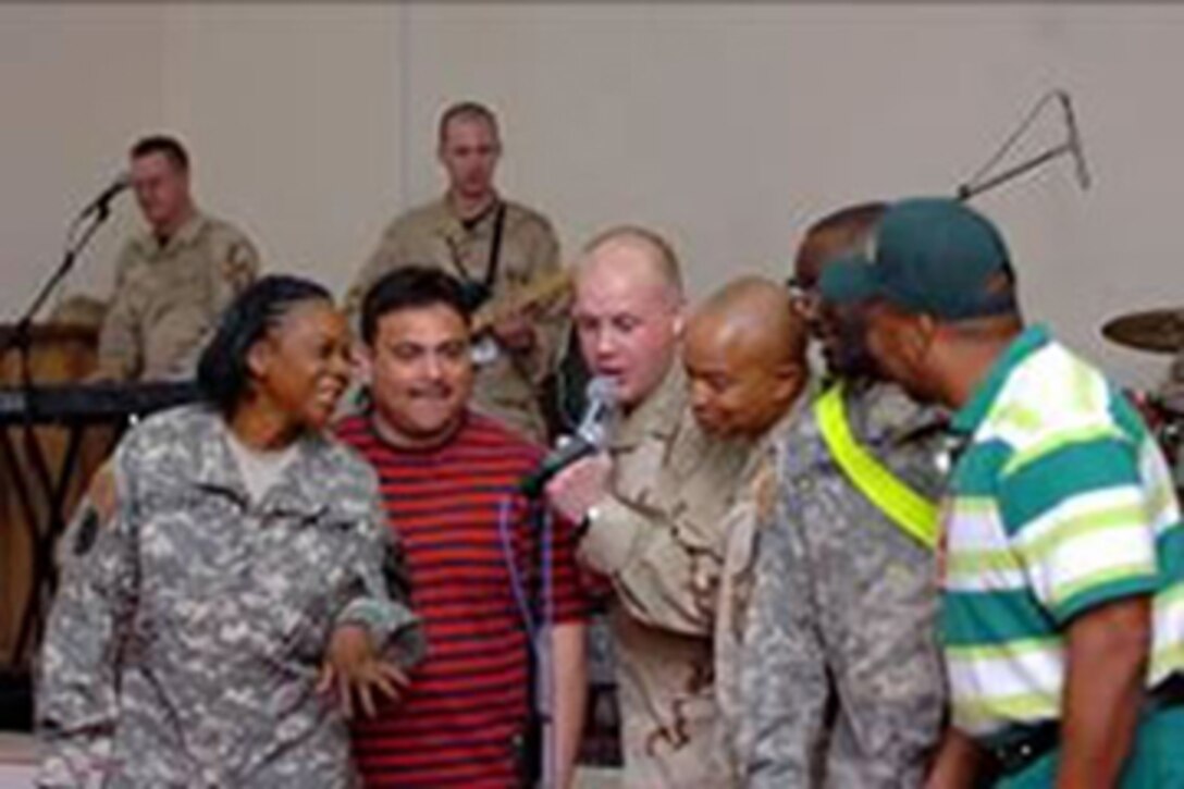 Members of the crowd get in on the act during a performance by Max Impact March 8. A rock ensemble from the Air Force, the group entertained Soldiers, Airmen and civilians on Camp Taji. (U.S. Army Photo by Spc. Karly Cooper, 15th SB PAO)
