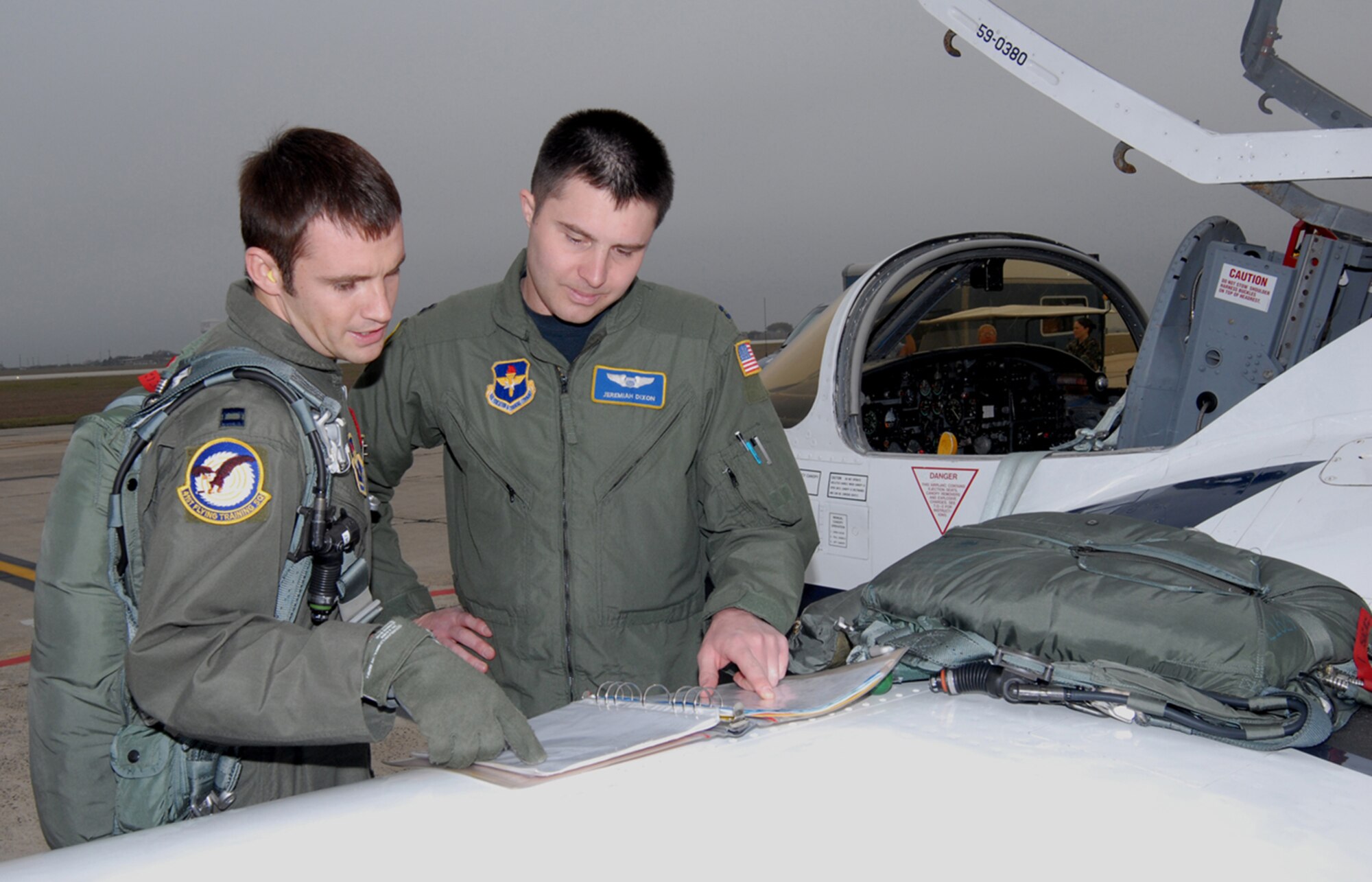 Capts. Lacy Gunnoe (left) and Jeremiah Dixon, 559th Flying Training Squadron T-37 instructor pilot students, review the aircraft forms prior to flight. (U.S. Air Force photo by Melissa Peterson)