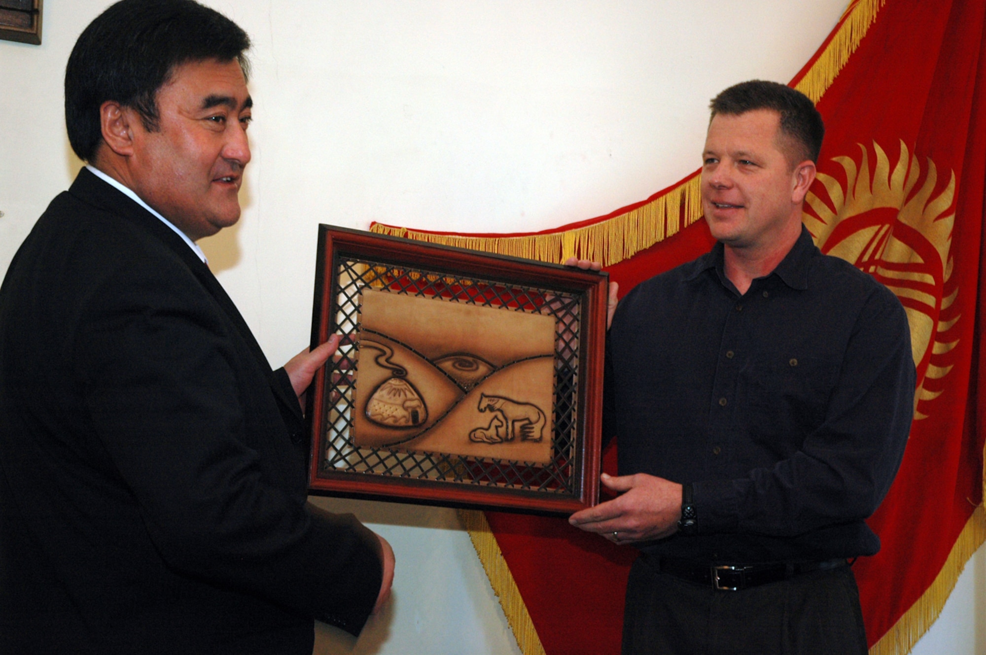 Bishkek, Kyrgyzstan, Mayor Arstankbek Nogoyev presents a gift for Colorado Springs, Colo., Mayor Lionel Rivera to Maj. Scott Suckow. Airmen deployed to Manas Air Base, representing the city of Colorado Springs, Colo., paid a visit to the mayor of its Sister City, Bishkek, Kyrgyzstan, March 14. Major Suckow is assigned to the 376th Expeditionary Medical Group. (U.S. Air Force photo/Master Sgt. Daniel Nathaniel)