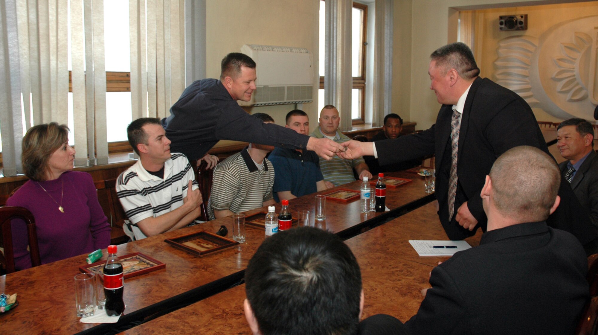 Major Scott Suckow presents a U.S. Air Force Academy coin March 14 to Urmatek Kadyrkulov, director of the Office of International Relations, for his help renewing sister city ties between Bishkek, Kyrgyzstan, and Colorado Springs, Colo. The coin was given on behalf fellow Airmen deployed to Manas Air Base. Major Suckow is assigned to the 376th Expeditionary Medical Group. (U.S. Air Force photo/Master Sgt. Daniel Nathaniel) 