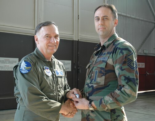 SPANGDAHLEM AIR BASE, Germany -- Gen. Tom Hobbins, U.S. Air Forces in Europe commander, coins Master Sgt. Allen Orahood, 52nd Maintenance Group, while at Spangdahlem Air Base to shoot an American Forces Network commercial here March 15.  