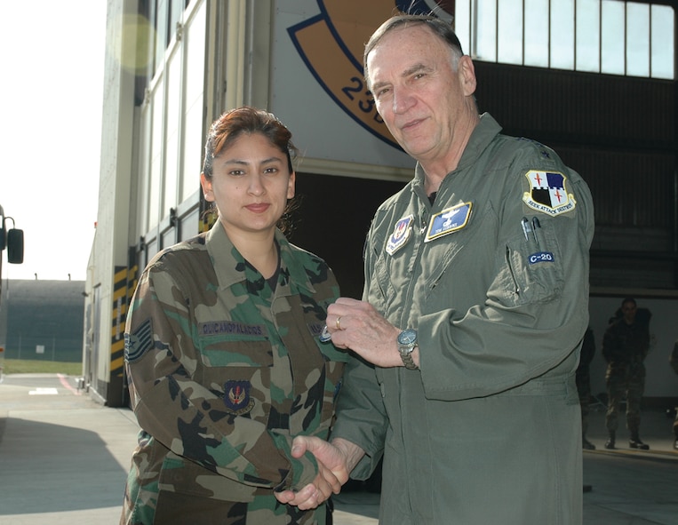 SPANGDAHLEM AIR BASE, Germany -- Gen. Tom Hobbins, U.S. Air Forces in Europe commander, coins Tech. Sgt. Margie Quicanopalacios, 52nd Fighter Wing, while at Spangdahlem Air Base to shoot an American Forces Network commercial here March 15.  