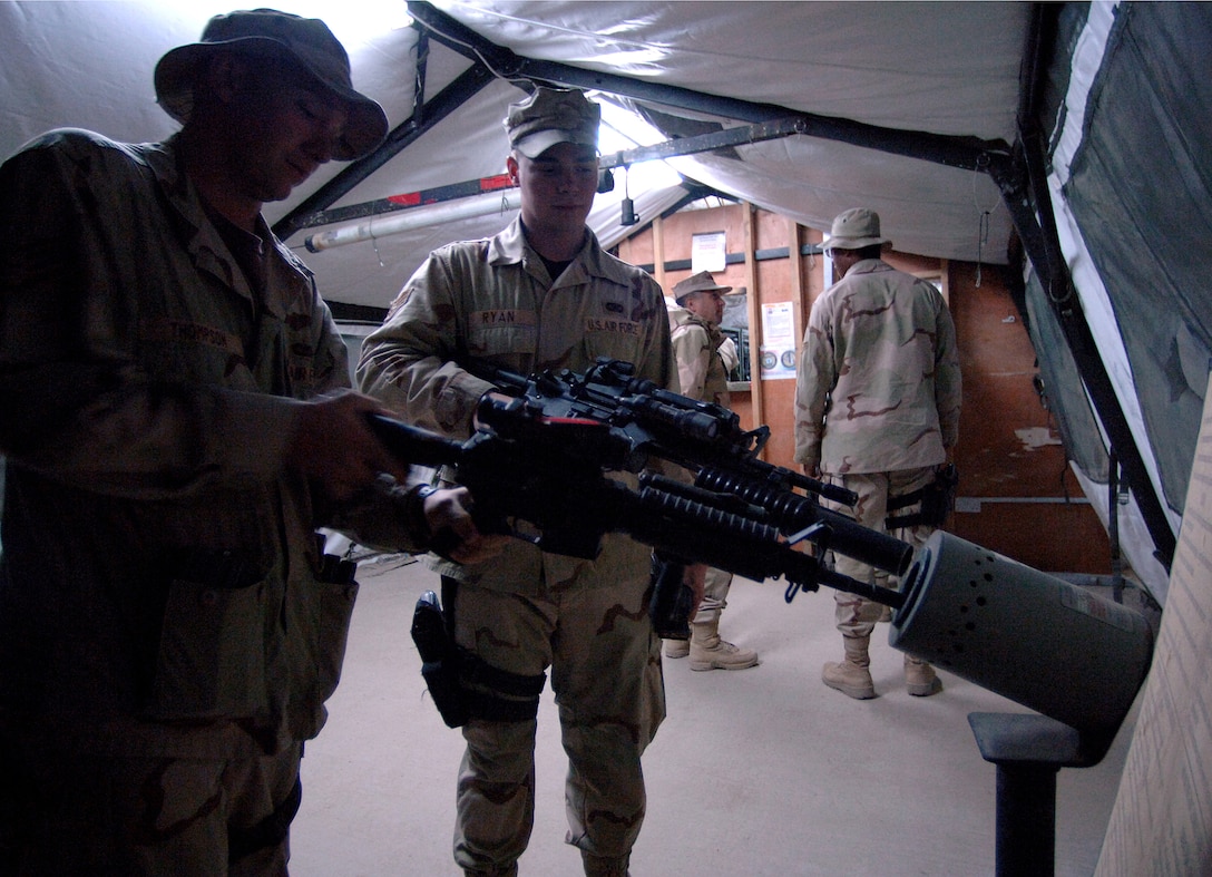 U.S. Air Force Staff Sgt. Robert Thompson and Senior Airman Shawn Ryan clear their M4 carbines at Camp Victory, Iraq, March 7, 2007, prior to departing to conduct a police transition team mission in Baghdad, Iraq.