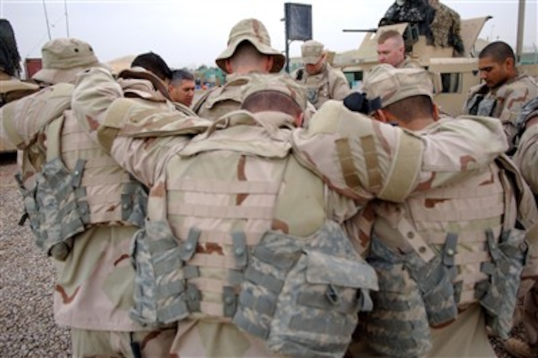 U.S. Air Force airmen from Detachment 7, 732nd Expeditionary Security Forces Squadron say a group prayer prior to departing Camp Victory, Iraq, on March 6, 2007, to conduct a police transition team mission in Baghdad, Iraq.  The airmen train Iraqi police on police station operations and patrol tactics.  