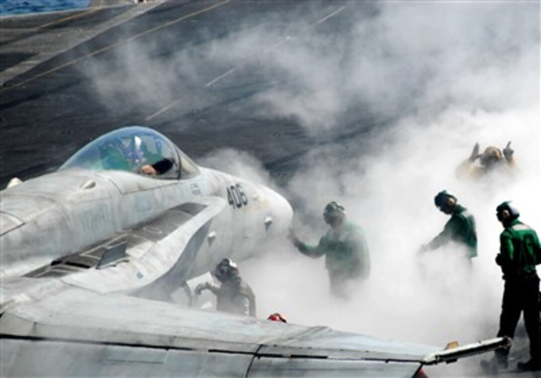 An F/A-18C Hornet aircraft from the "Argonauts" of Strike Fighter Squadron One Four Seven is directed into launch position in front of a steam powered catapult, March 16, 2007.