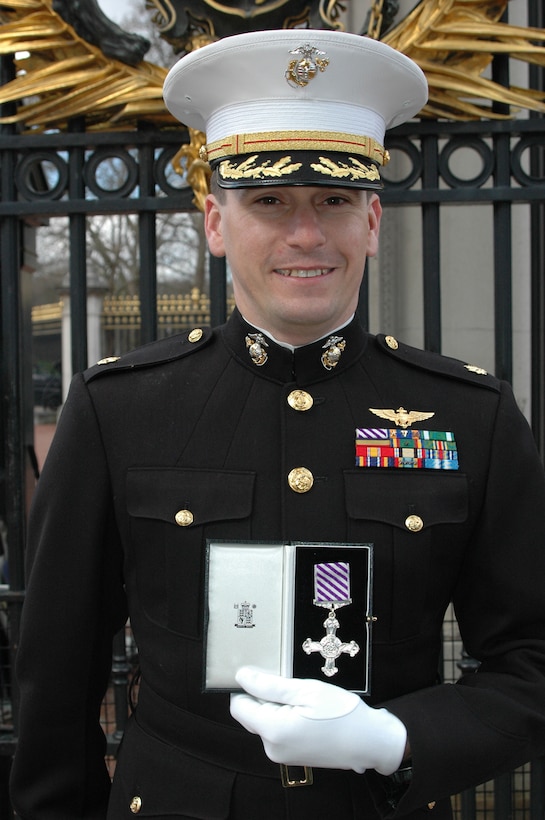 Major William D. Chesarek Jr., an U.S. Marine Corps exchange officer serving with the United Kingdom?s 847th Naval Air Squadron, Commando Helicopter Force, stands in front of Buckingham Palace with the UK?s Defense Flying Cross presented to him by Queen Elizabeth II here March 21.  Chesarek is credited for heroic actions during combat operations in Iraq 10-11 June 2006.