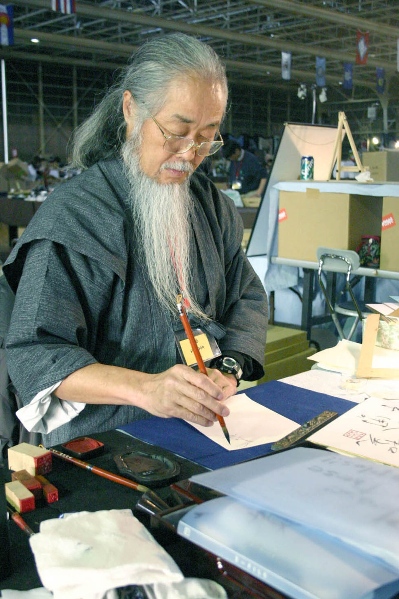 060331--MISAWA AIR BASE, Japan -- Kanji artist, Hikaru Hachiyo, was one of the vendors who took part in the Officers Spouses' Club Bazaar March 25, 2006. The annual Far East Bazaar features crafts and furniture that gave families here a chance to expeirence more of the Asian culture. It also raised money for base organizations. The 2007 even is scheduled for March 31 and April 1 in Hangar 949. (U.S. Air Force photo by Staff Sgt. Vann Miller)