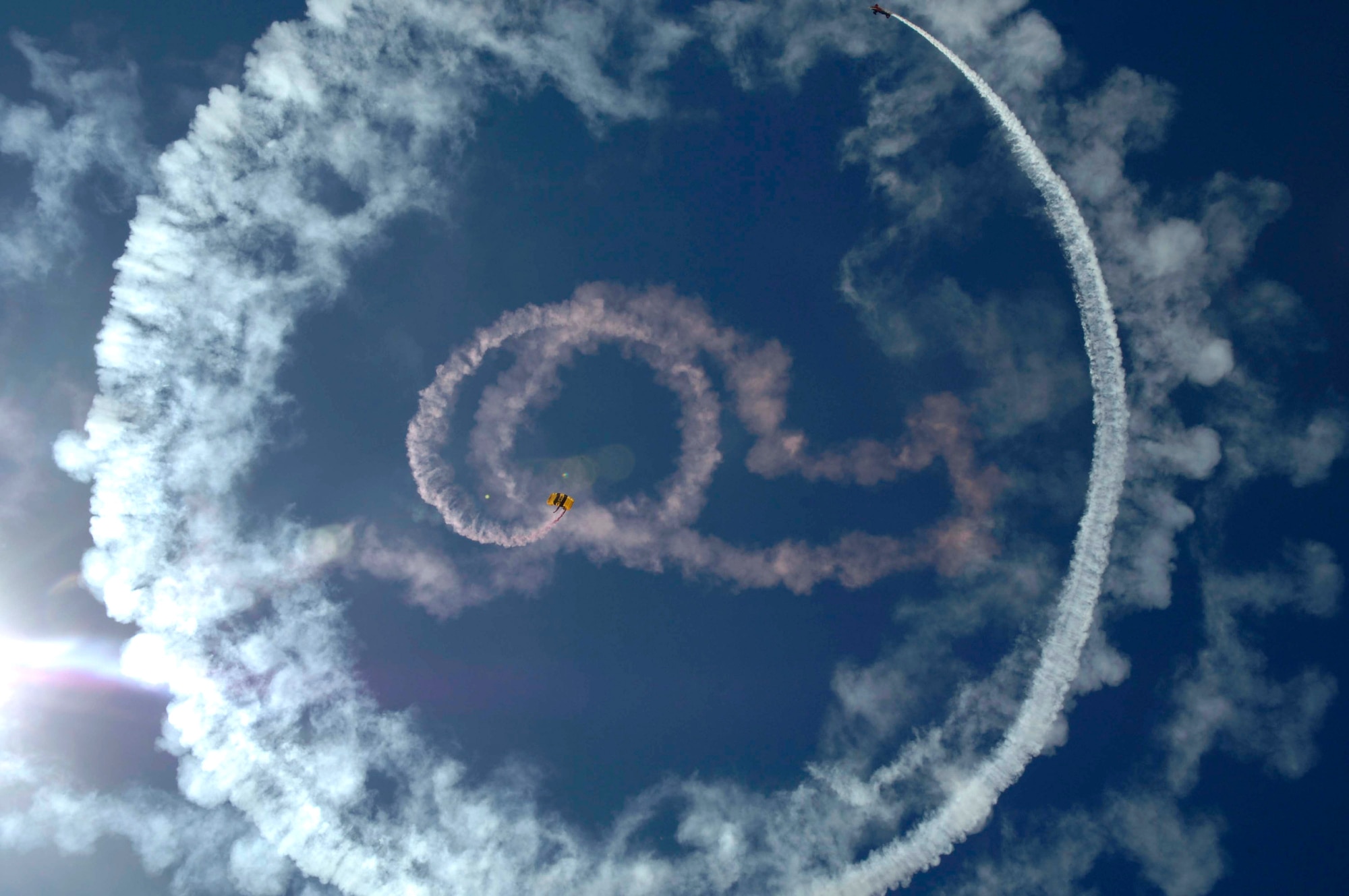 A member of the Golden Knights U.S. Army parachute team descends while a stunt plane flies around the parachutist March 18 during the 2007 Aerospace and Arizona Days air show at Davis-Monthan Air Force Base, Ariz.  The two-day air show offered public an up-close look at military and civilian aerial demonstrations and static-display aircraft from across the U.S. The theme for this year's show was "Davis-Monthan and Tucson: 80 Years of Airpower for America!"  (U.S. Air Force photo/Senior Airman Christina D. Ponte)