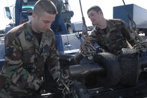 MINOT AIR FORCE BASE, N.D. -- Senior Airman Chad Wilson and Staff Sgt. Michael Stewart, both from the 5th Logistics Readiness Squadron vehicle operations, hook a vehicle to a tow truck March 16, 2007. The 5th LRS vehicle operations was recently awarded best vehicle operations in Air Combat Command for 2006. (U.S. Air Force photo by Airman 1st Class Cassandra Butler)