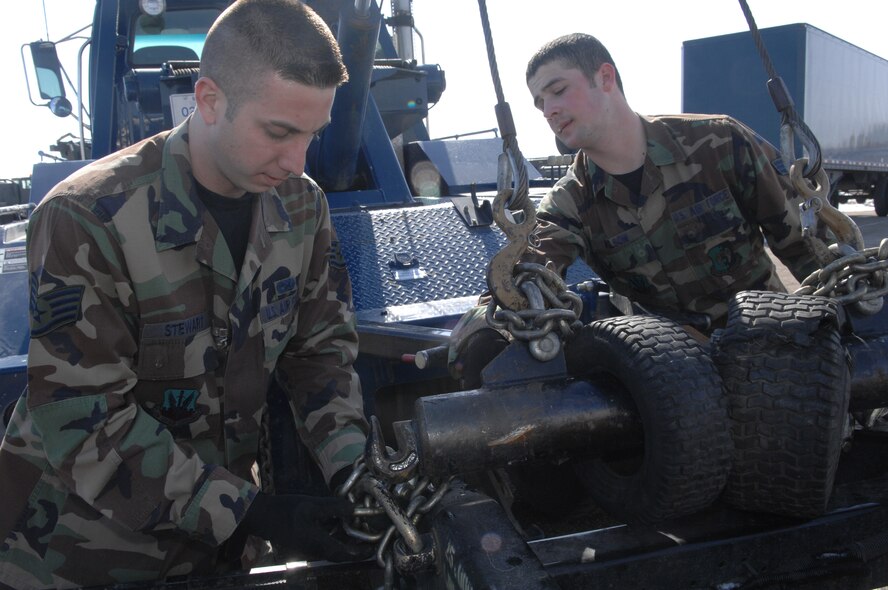 MINOT AIR FORCE BASE, N.D. -- Senior Airman Chad Wilson and Staff Sgt. Michael Stewart, both from the 5th Logistics Readiness Squadron vehicle operations, hook a vehicle to a tow truck March 16, 2007. The 5th LRS vehicle operations was recently awarded best vehicle operations in Air Combat Command for 2006. (U.S. Air Force photo by Airman 1st Class Cassandra Butler)