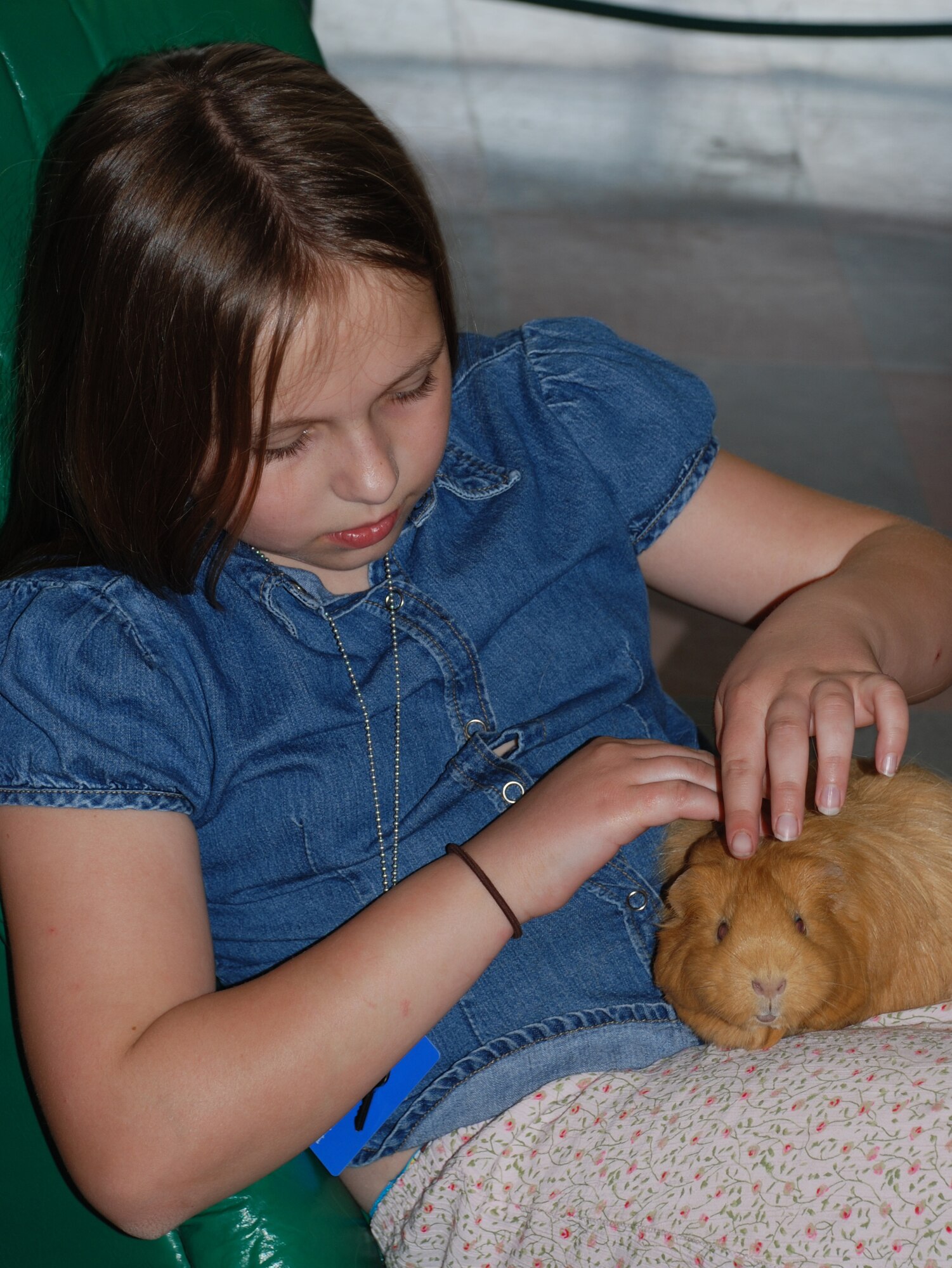 Erin Bosma plays with Lilly the Guinea pig March 15 at the Youth Center.  (U.S. Air Force photo/Adrian McCandless)