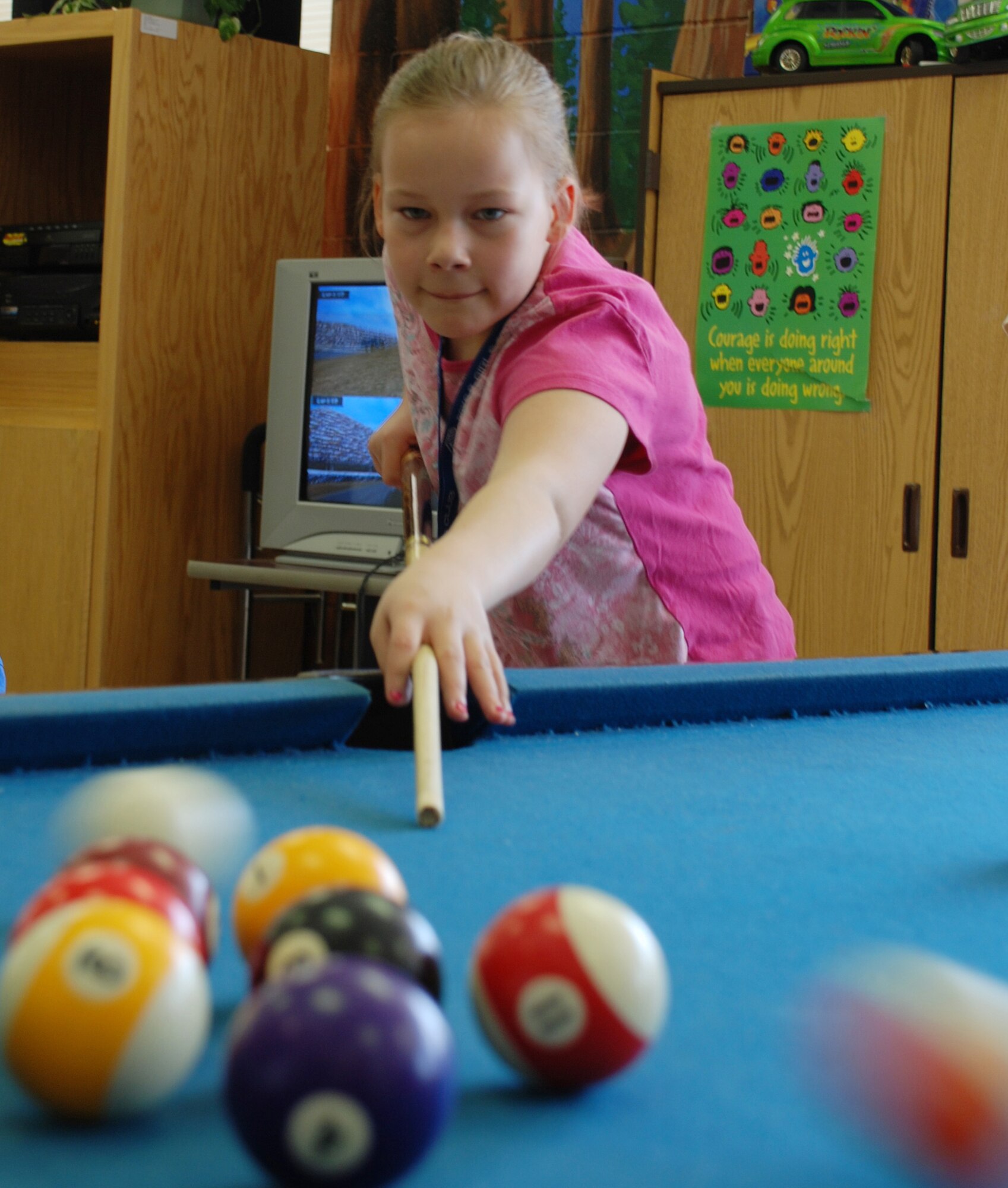 Veronica Schroeder concentrates in a game of pool March 15 at the youth center while at the center's spring break camp. (U.S. Air Force photo/Adrian McCandless)