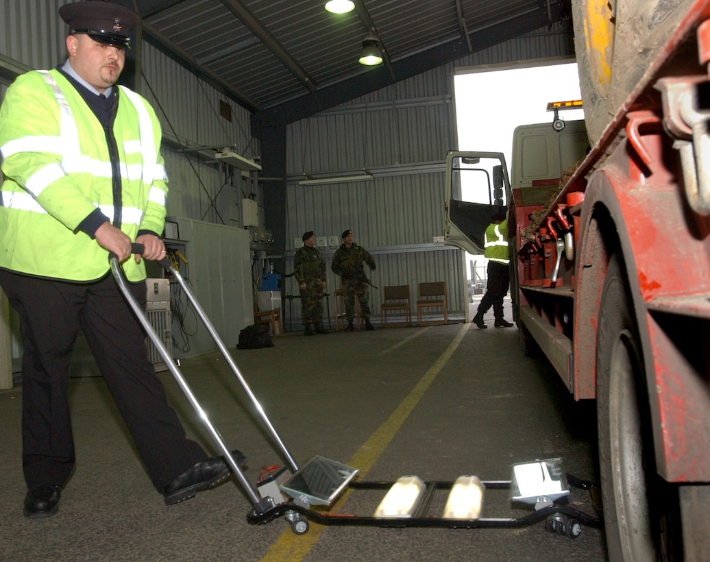 Civilian Security Officer 5 Mark Hilton checks the undercarriage of a truck using a vehicle search mirror at the base search barn February 16, 2007.  The search barn is the first line of defense in force protection.  Vehicles coming through are inspected for explosives, unauthorized persons, contraband and illegal weapons. (U.S. Air Force photo by Staff Sgt. Vanessa Bastidas)