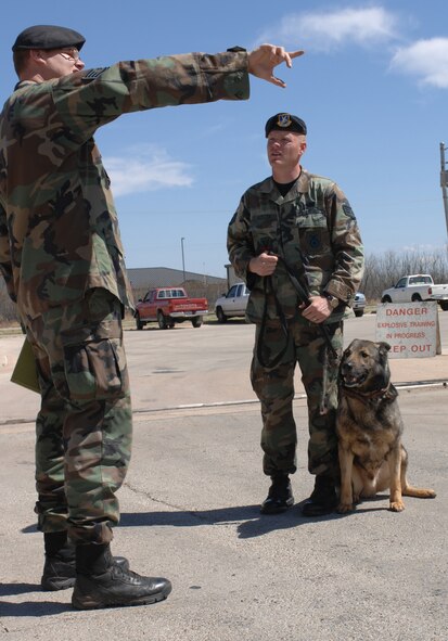 Tech. Sgt. Christopher Juvrud, 7th Security Forces Squadron, explains to Staff Sgt. Joshua Webster, 7th SFS K-9 handler, what is expected of him and where to go for K-9  detection training March 15. A new handler and his K-9 must get to know each other's every move and reaction. (U.S. Air Force photo by Airman Jennifer Romig)