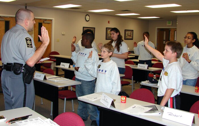 Drug Education for Youth program participants swear in as junior deputy officers during the phase II DEFY March workshop. Guest speaker, Deputy John Droney from the Charleston County Sheriff?s Office, instructed the class on gang resistance and dealing with bullies. (U.S. Air Force photo by Tech. Sgt. Nina Murphy)                       