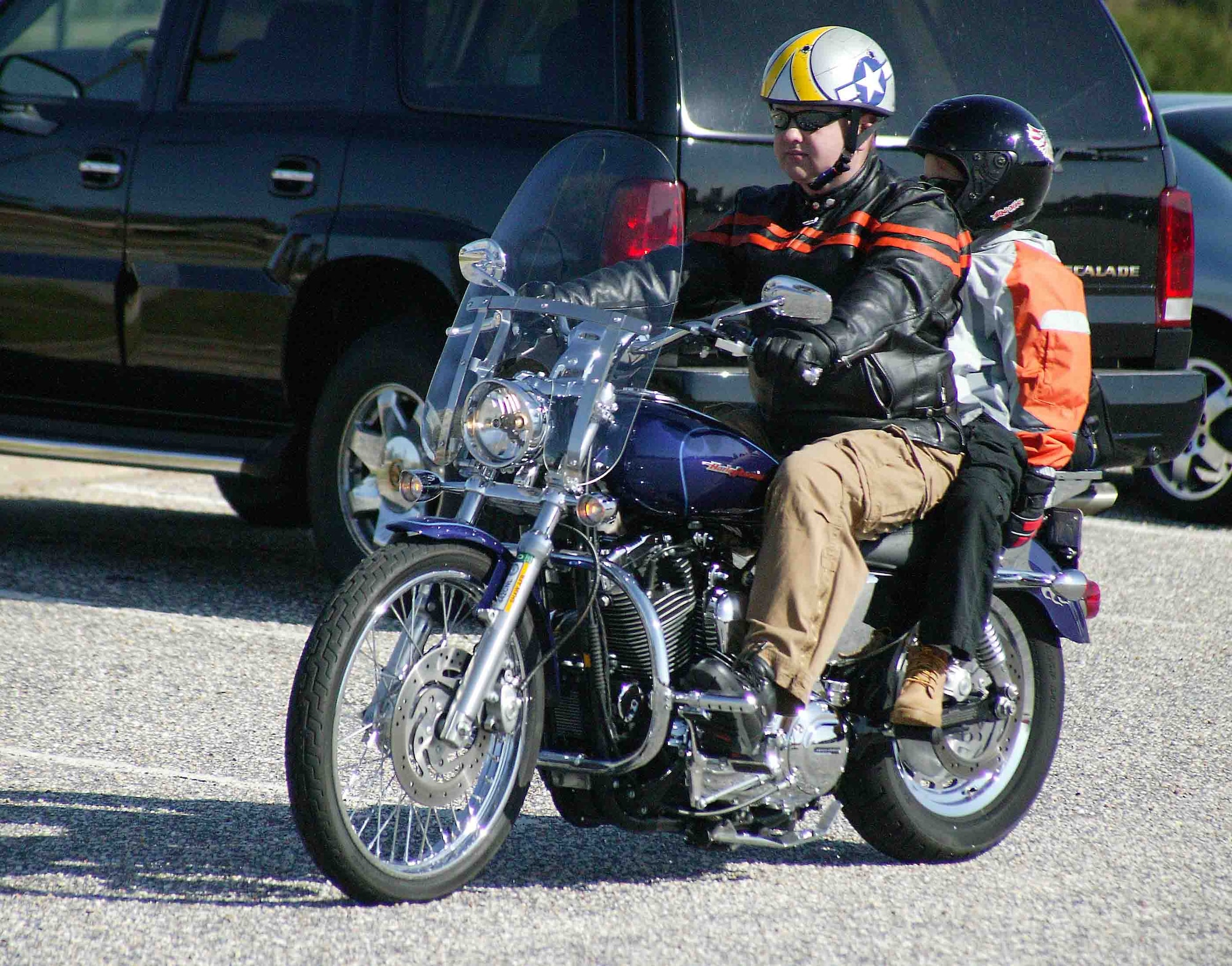 SHAW AIR FORCE BASE, S.C. -- Staff Sgt. Sean Anderson, 20th Medical Support Squadron, and his son arrive at the Shaw Motorcycle Riders Association bike show March 17. The SMRA hosted the bike show to promote motorcycle safety and awareness. Sergeant Anderson won the "Best Cruiser" title. (U.S. Air Force photo/Senior Airman John Gordinier) 