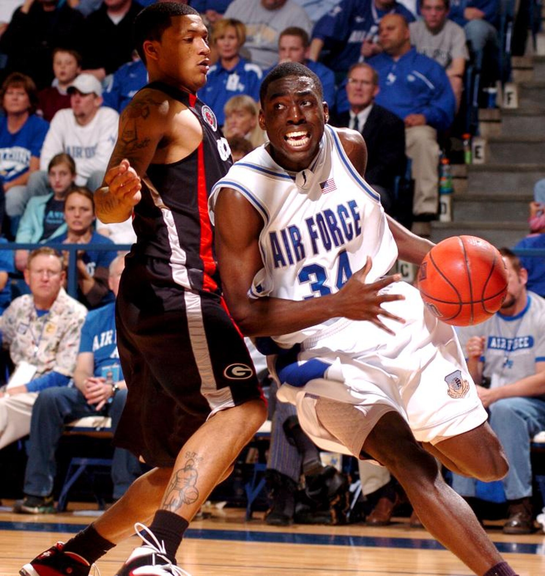 Air Force forward Dan Nwaelele breaks past Georgia guard Billy Humphrey for the basket March 19 at the Academy's Clune Arena. Nwaelele scored 19 points on the night. With the 83-52 win in the second round of the National Invitation Tournament, Air Force set a new record for wins in a season at 25. (U.S. Air Force photo/1st Lt. John Ross)