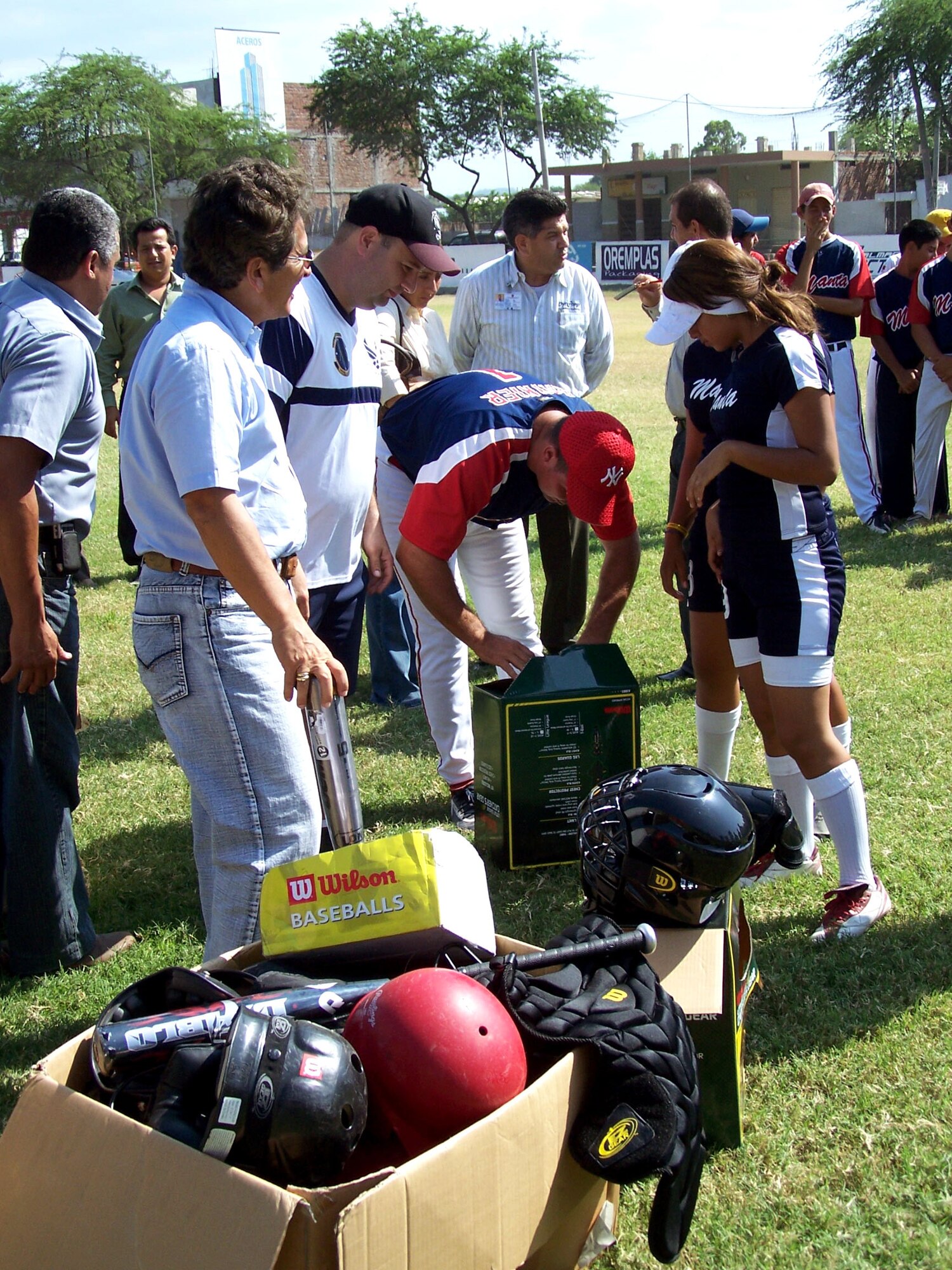 Lt. Col. Javier Delucca (second from left) and Manta City Mayor Jorge Zambrano watch as Raynier Rabelo, Manta Baseball Academy director, opens the first box of donated baseball equipment. Colonel Delucca is commander of the 478th Expeditionary Operations Squadron. (U.S. Air Force photo/Maj. Chris Hemrick) 

