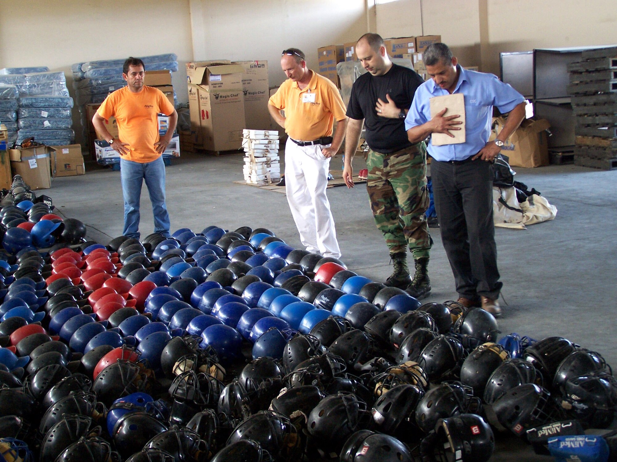Alfonso Ribot (right) inventories donated baseball equipment inside a warehouse alongside 478th Expeditionary Operations Squadron Commander Lt. Col. Javier Delucca (second from right) and two Dyncorp employees. (U.S. Air Force photo/Maj. Chris Hemrick)
