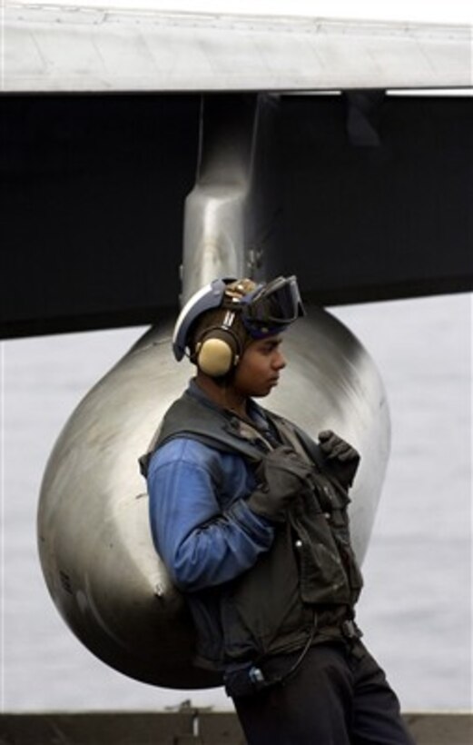 U.S. Navy Airman Michael Perez leans against a fuel drop tank of an F/A-18E Super Hornet aircraft on the flight deck of the USS Ronald Reagan (CVN 76) as the ship operates in the Pacific Ocean on March 16, 2007.  The Ronald Reagan Carrier Strike Group is underway in the Pacific in support of U.S. military operations.  