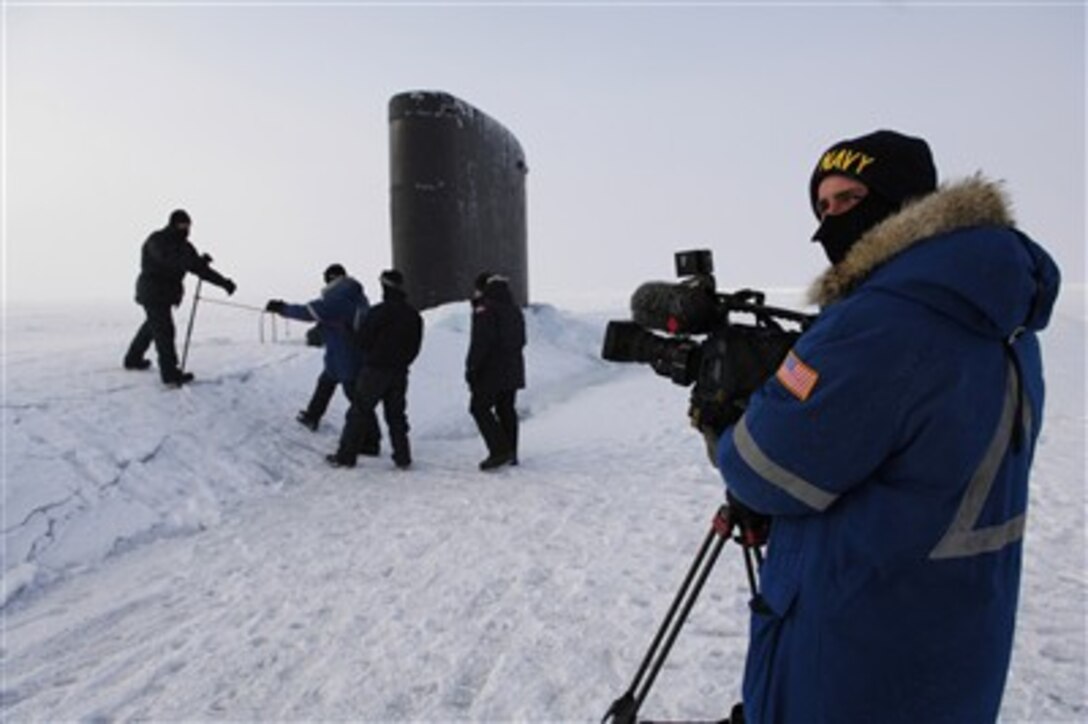 Navy Petty Officer 2nd Class Andrew Krauss prepares to videotape visitors to the Los Angeles-class fast-attack submarine USS Alexandria (SSN 757) in the Arctic Ocean on March 17, 2007.  Alexandria is taking part in exercise ICEX 07 with the Royal Navy submarine HMS Tireless (SS 88) and the applied physics ice station.  The exercise is in support of arctic testing for U.S. and United Kingdom submarines being conducted on and under a drifting ice floe about 180 nautical miles off the north coast of Alaska.  