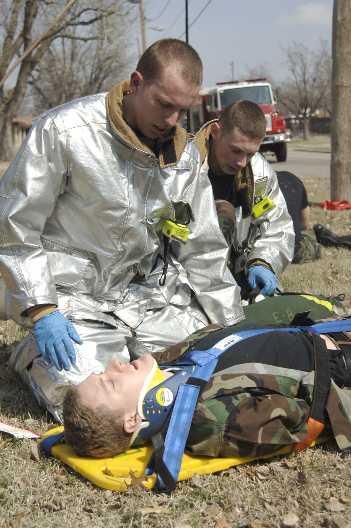Senior Airman Gregory Godfrey, left, and Senior Airman Cory Brown, right, both 22nd Civil Engineer Squadron firefighters, check a mock tornado victim for injuries March 13 in McConnell's residential area as part of a tornado response exercise. During the exercise, McConnell's exercise evaluation team primarily assessed the effectiveness of the base's emergency notification systems. The EET also evaluated Team McConnell members' ability to shelter-in-place and each unit's capability to account for its members in an emergency situation. (Air Force photo by Airman 1st Class Roy Lynch)