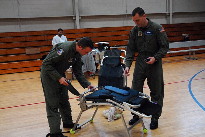 Staff Sgt. Joshua D. Pogue, 437th Operations Support Squadron Combat Tactics Flight instructor loadmaster, and Staff Sgt. Eric R. Embaugh, 437 OSS Combat Tactics Flight joint airdrop inspector loadmaster, fold up a donor bed as volunteer work after a blood drive at the Fitness and Sports Center March 21. (U.S. Air Force photo/Airman Melissa B. Harper)