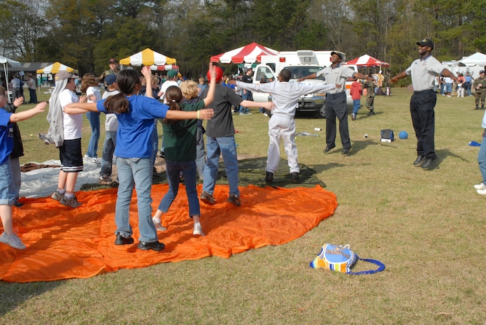 Senior Airmen Tavarus Williams and Clinton Coleman, both 437th Services Squadron fitness specialists, do jumping jacks with Westview Elementary School students as part of the Earth Day celebration March 21. (U.S. Air Force photo/Airman Melissa B. Harper)