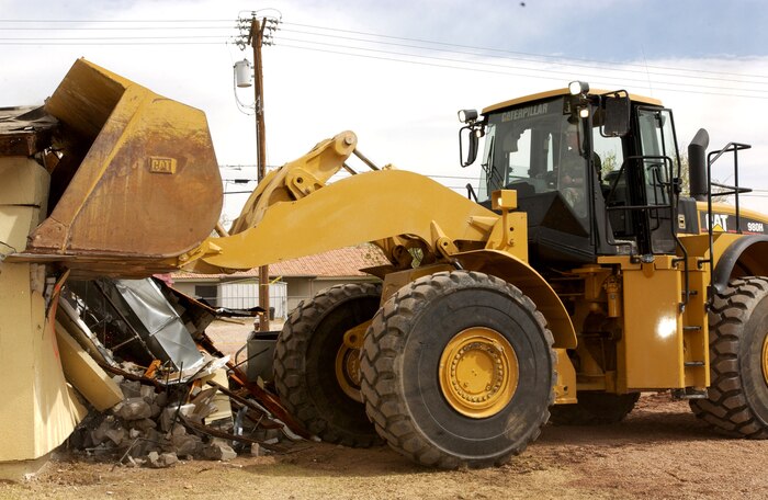 Col. Michael Bartley, 99th Air Base Wing commander, Nellis Air Force Base, Nev., drives the bulldozer that demolished the first home March 20, 2007, to make way for modern houses for military families.  (U.S Air Force photo by Senior Airman Larry E. Reid Jr.)