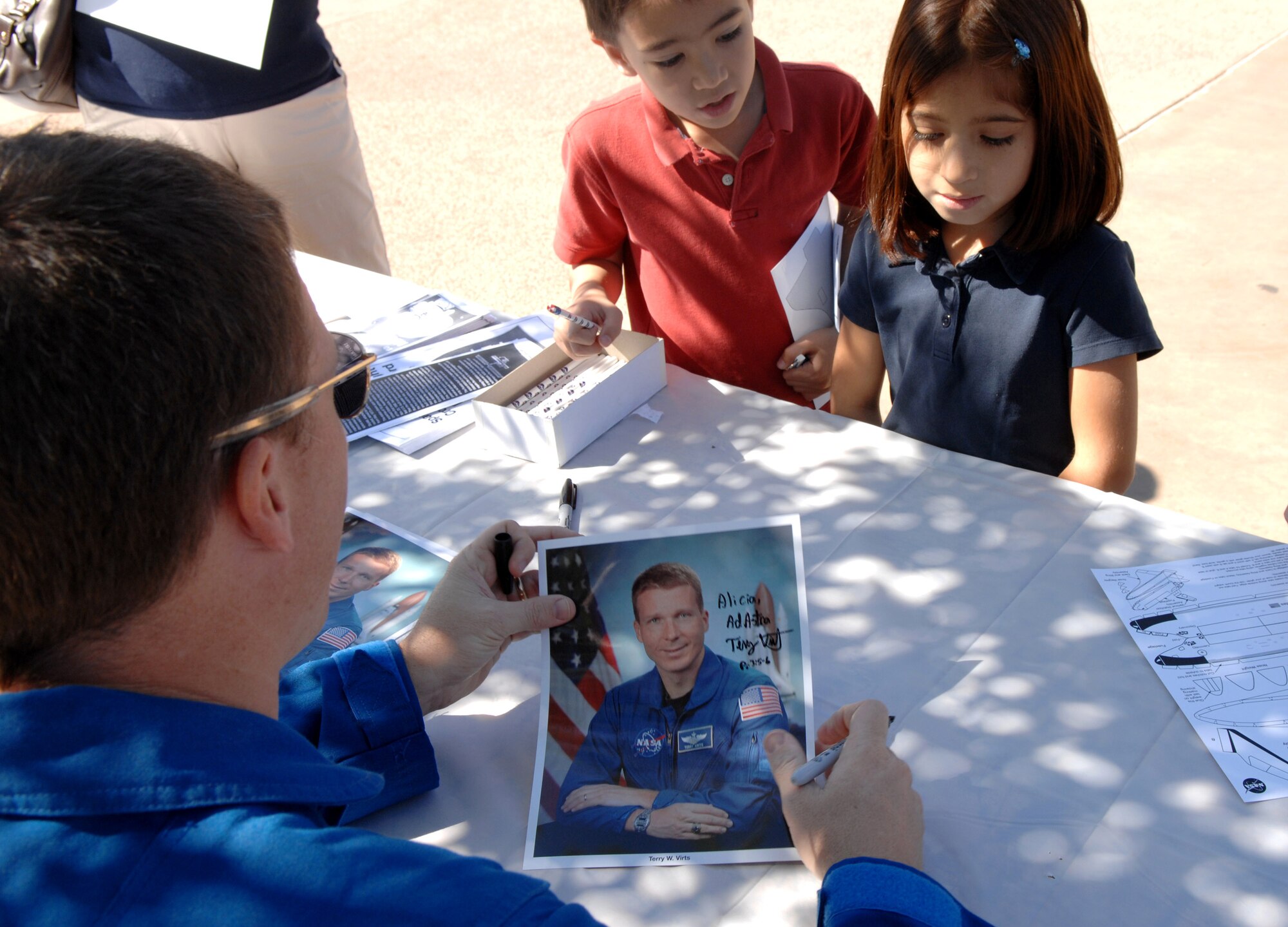 NASA Astronaut Lt. Col. Terry Virts autographs a photo March 20 during Air Force Week at the Arizona Science Center in downtown Phoenix.  Colonel Virts answered questions about his role as an astronaut and Air Force member.  (U.S. Air Force photo/Staff Sgt. Brian Ferguson)