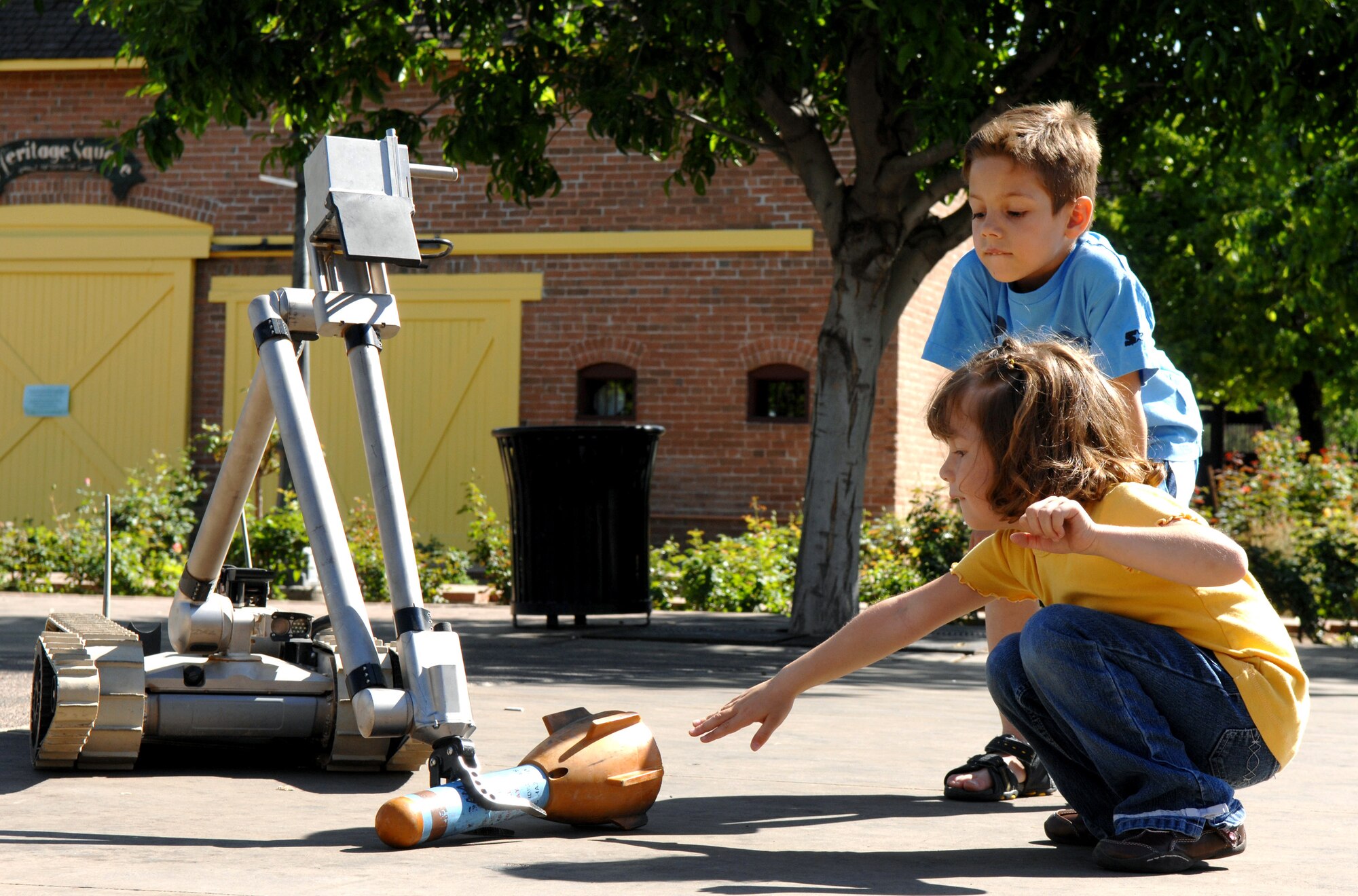 Antonia Ortiz, age 6, and Teresa Ortiz, age 4, watch as an explosive ordnance disposal robot reaches down to retrieve a simulated bomb March 20. The display was part of Air Force Week at the Arizona Science Center in downtown Phoenix. (U.S. Air Force photo/Staff Sgt. Brian Ferguson)