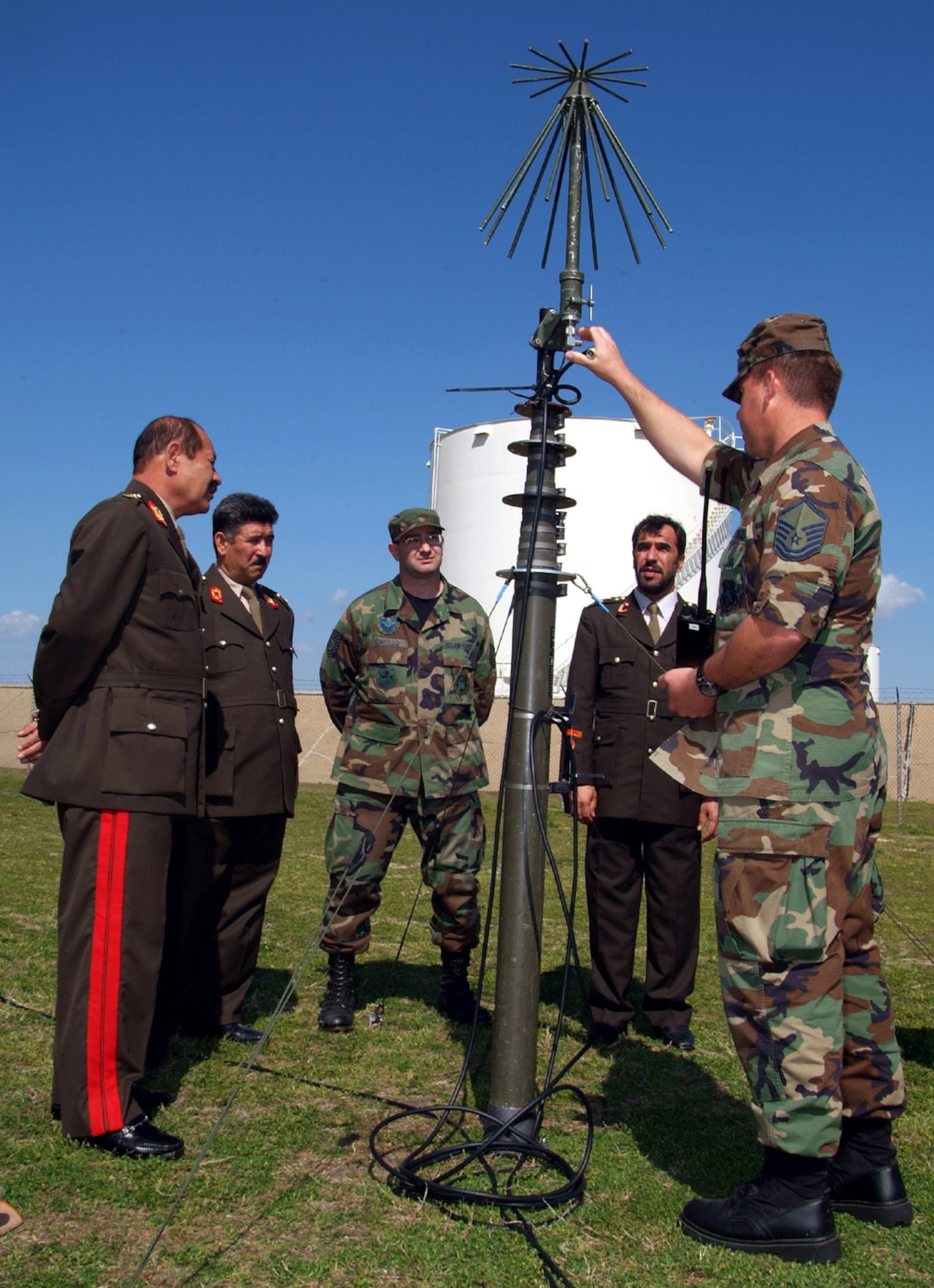 Major Gen. Mehrab Ali, Brig. Gen. Baba Mirza, Tech. Sgt. Joseph Carello, Col. Said Farooq Yosuf Zai and Master Sgt. Edward Rush discuss the features of a 50-foot telescoping mast assembly and capabilities of the UHF omni-directional antenna used for tactical ground-to-air communications. The officers are members of the Afghan National Army.Sergeants Carello and Rush are instructors with the 338th Training Squadron at Keesler Air Force Base, Miss. (U.S. Air Force photo)