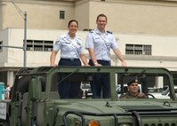 Lackland Ambassadors Tech. Sgt. Magdalena Cortez and Capt. C. Brent Dishman are escorted through downtown San Antonio during the 39th annual St. Patrick's Day street parade March 17. The theme of the 39th annual St. Patrick's Day Parade was "The Green Honors the Blue." The parade had a blend of participants from civic, social, business, educational, patriotic and military organizations. (USAF photo by Alan Boedeker)                                
