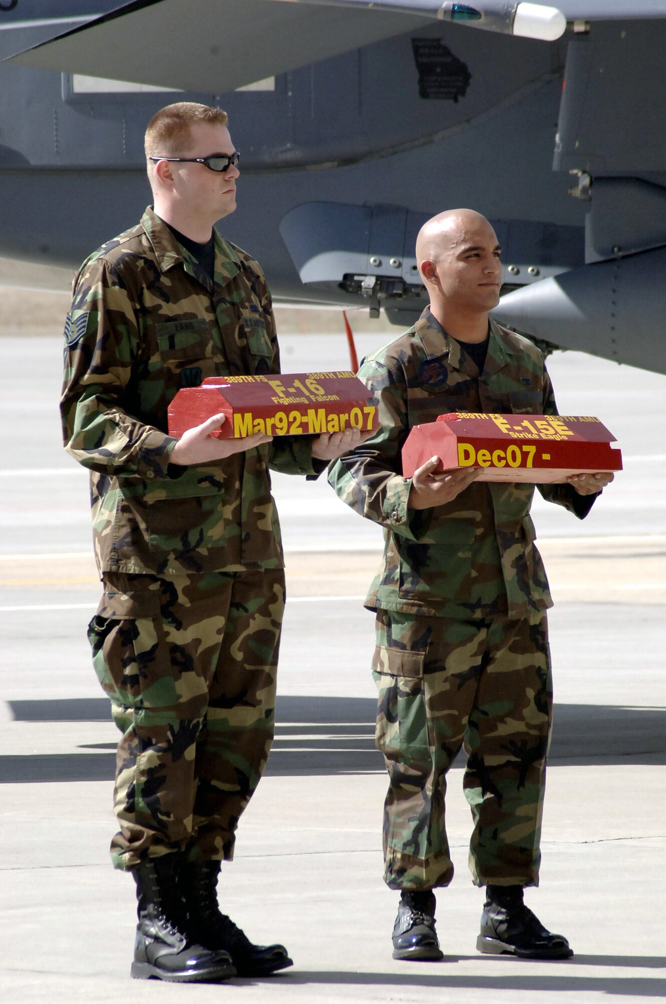 MOUNTAIN HOME AIR FORCE BASE, Idaho -- Symbolizing the transfer of the 389th Fighter Squadron’s led aircraft, Staff Sgt. David Lang passes his aircraft’s wheel chalks to Senior Airman Jaime Montano during the squadron’s “fini flight” ceremony here March 16. Sergeant Lang served as the dedicated crew chief for the squadron’s lead F-16 up until the squadron officially transferred the unit’s role to the F-15E Strike Eagle at the event. The squadron’s last five F-16s permanently leave the base March 29 as part of the 366th Fighter Wing’s move to a core F-15E unit. Air Force photo by Master Sgt. Dave Wheeler