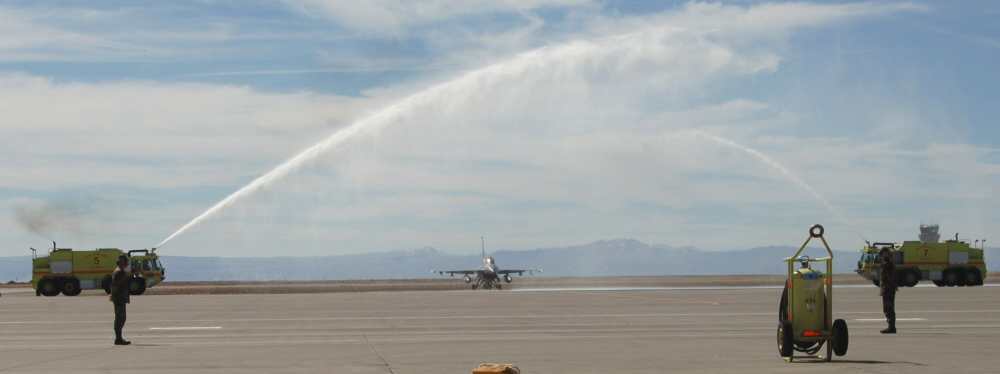 MOUNTAIN HOME AIR FORCE BASE, Idaho -- Fire trucks from the base fire station shoot streams of water over an F-16CJ to commemorate the jet’s last training mission here March 16. The jet, flown by 389th Fighter Squadron Commander Lt. Col. Phillip Hoover, is one of the squadron’s five remaining F-16s preparing to leave the base as part of the wing’s ongoing realignment to F-15E Strike Eagles. Air Force photo by Staff Sgt. Carly Burke