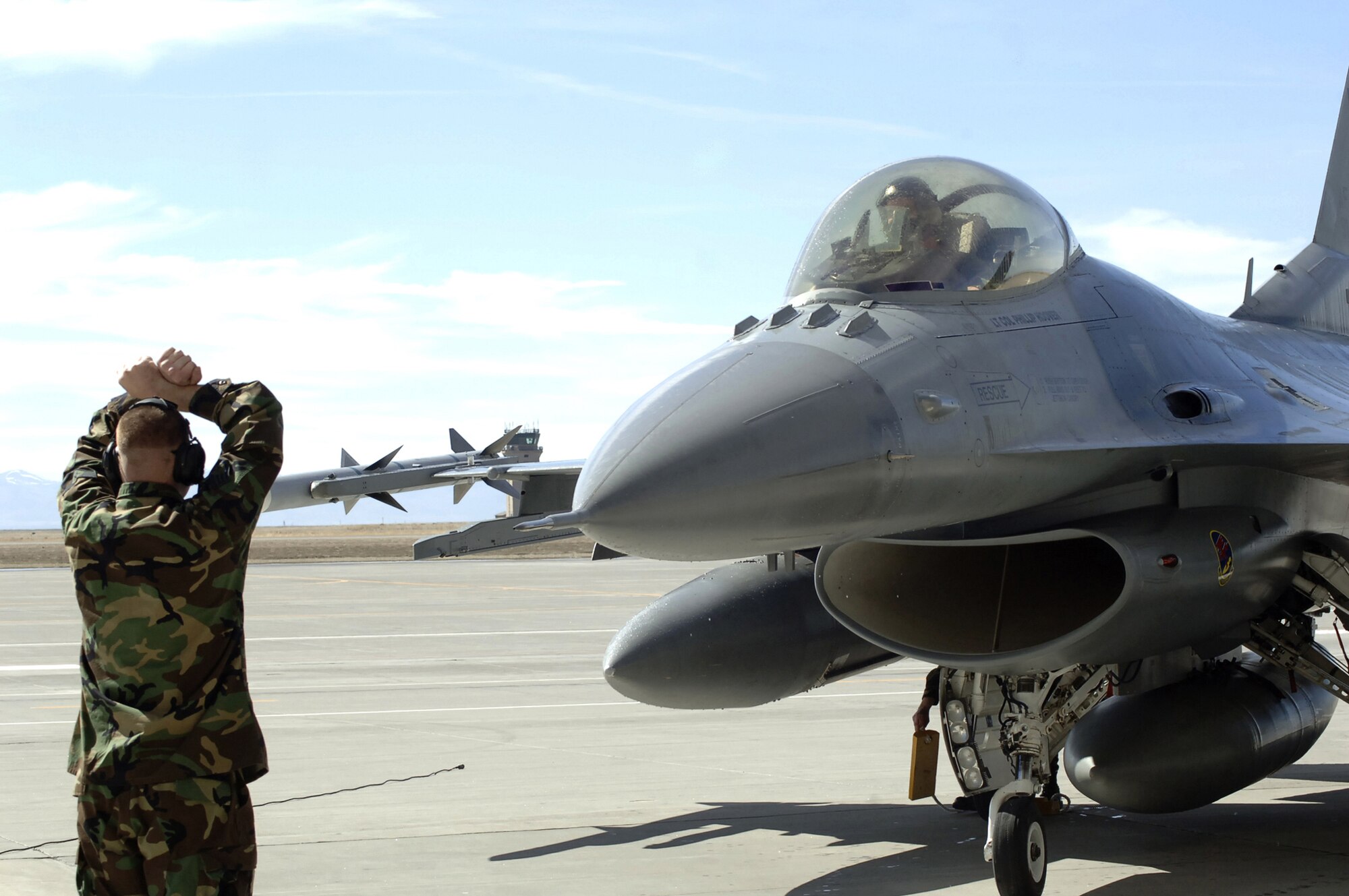 MOUNTAIN HOME AIR FORCE BASE, Idaho -- Staff Sgt. David Lang, a dedicated crew chief with the 389th Aircraft Maintenance Unit, signals an F-16CJ to stop at its parking spot in front of Hangar 201 during the 389th Fighter Squadron’s “fini flight” ceremony here March 16. Flown by 389th FS Commander Lt. Col. Phillip Hoover, the aircraft’s mission marked the last time the squadron will fly F-16s here. The squadron’s last five F-16s permanently leave the base March 29. Air Force photo by Master Sgt. Dave Wheeler