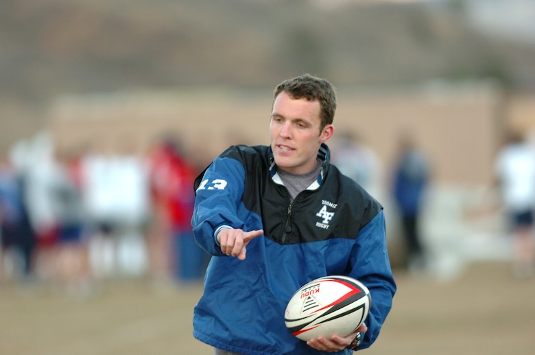 Cadet 2nd Class Marc Ward motions March 20 to Air Force Academy rugby players to move the ball down the field. Cadet Ward suffered a debilitating injury during a rugby game in 2003 in a game against the University of California at Berkeley. He lost full use of his right arm for six months, but has since made a full recovery and now coaches as part of the academy rugby team. (U.S. Air Force photo/1st Lt. John Ross)