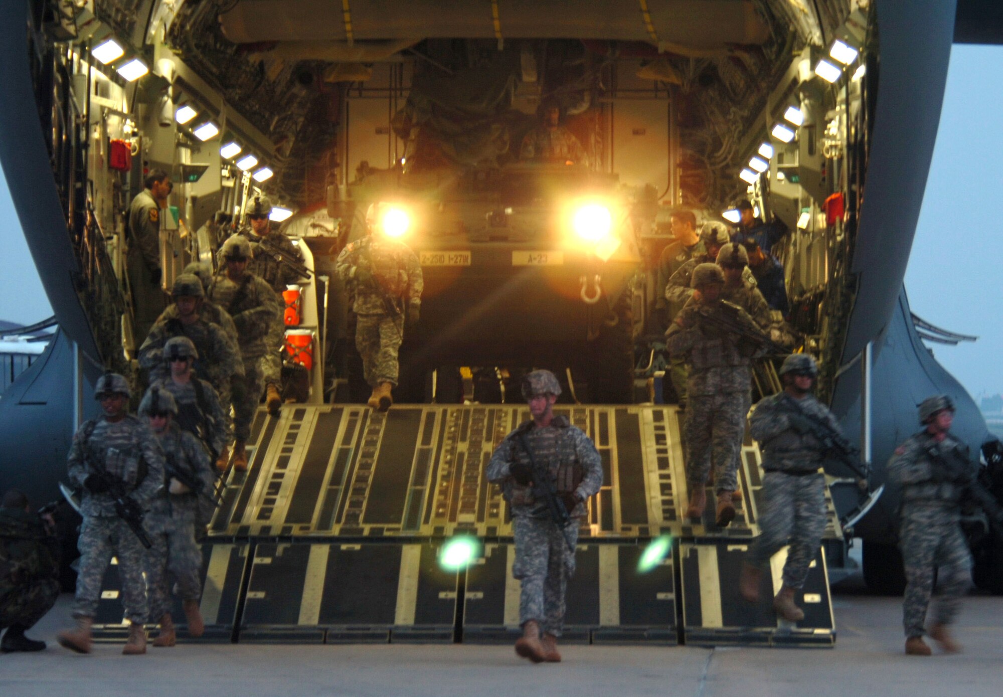 Soldiers from the 27th Infantry Division spread out to provide security as an M1126 Stryker infantry carrier vehicle is offloaded from a C-17 Globemaster III March 18 in Daegu, South Korea, for Exercise Foal Eagle 2007.  The focus of the exercise is on strategic, operational and tactical aspects of general military operations in the Korean theater of operations.  Its intent is to demonstrate resolve to support the Republic of Korea against external aggression while improving ROK - U.S. combat readiness and joint and combined interoperability. The C-17 is from the 15th Airlift Wing at Hickam Air Force Base, Hawaii. (U.S. Navy photo/Petty Officer 2nd Class Sandra M. Palumbo)