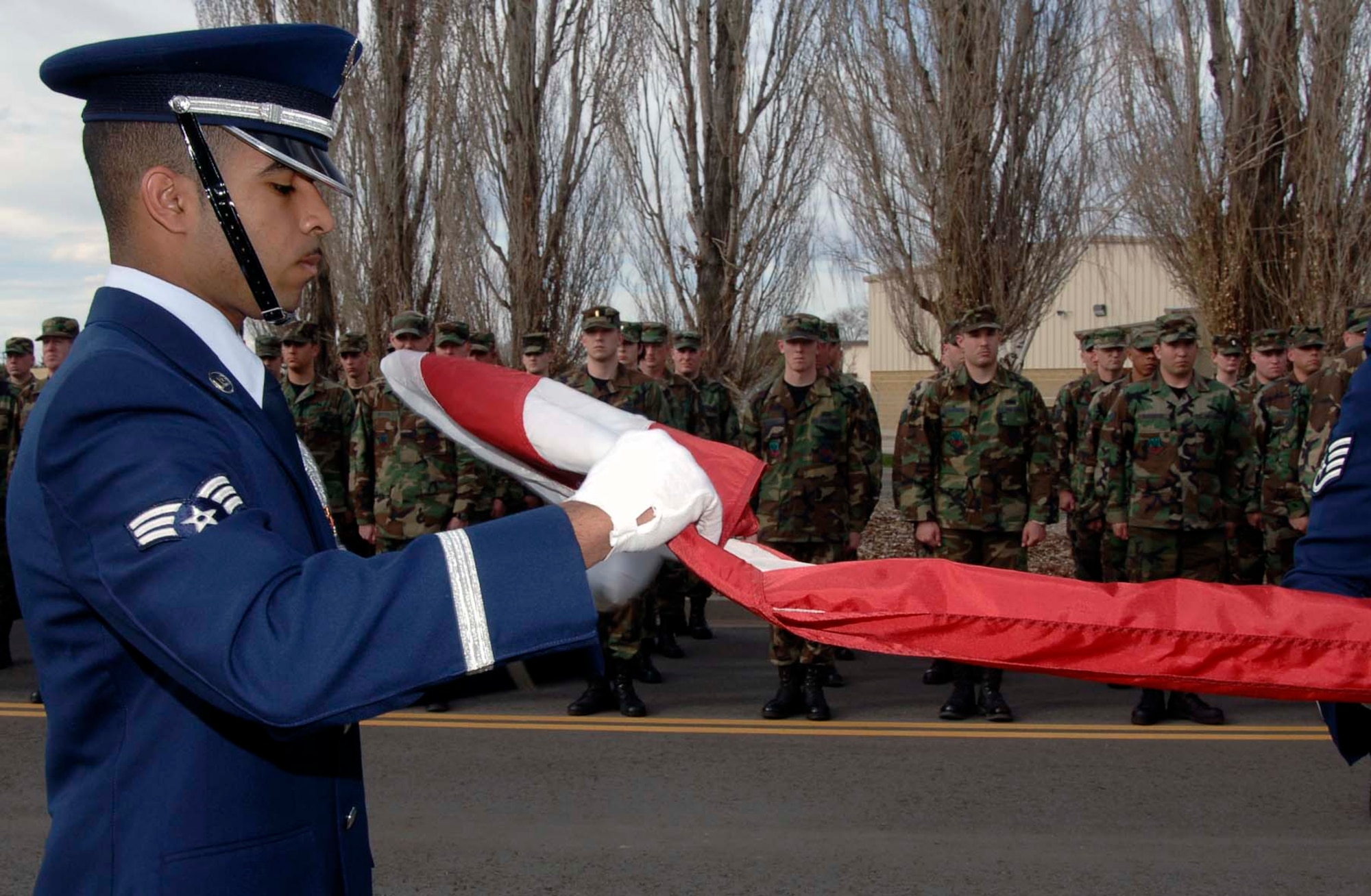 MOUNTAIN HOME AIR FORCE BASE, Idaho -- Senior Airman Emmanuel Santillan from the base honor guard folds the flag during a retreat ceremony here March 19.  Members of the 366th Mission Support Group stood in formation as part of the event. The base holds these formal retreats once a month from March to October with one of the wing's four groups responsible for conducting the formation. Air Force photo by Airman 1st Class Stephany Miller