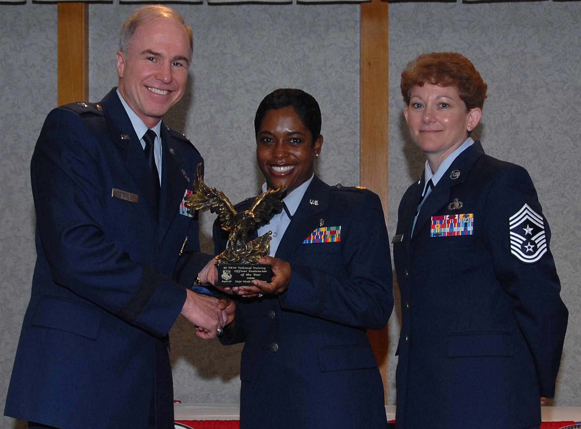 Maj. Wanda Parham-Bruce of the 882nd Training Group accepts the 82nd Training Wing Officer Instructor of the Year award March 19 from 82nd TRW Commander Brig. Gen. Richard Devereaux and 82nd TRW Command Chief Chief Master Sgt. Jeannie McLean.  Major Parham-Bruce directed a nationally accredited $1.5 million optometry training program, briefed at the Federal Service Optometry seminar and was the group Freedom Fest project officer. (U.S. Air Force photo/Mike Litteken)