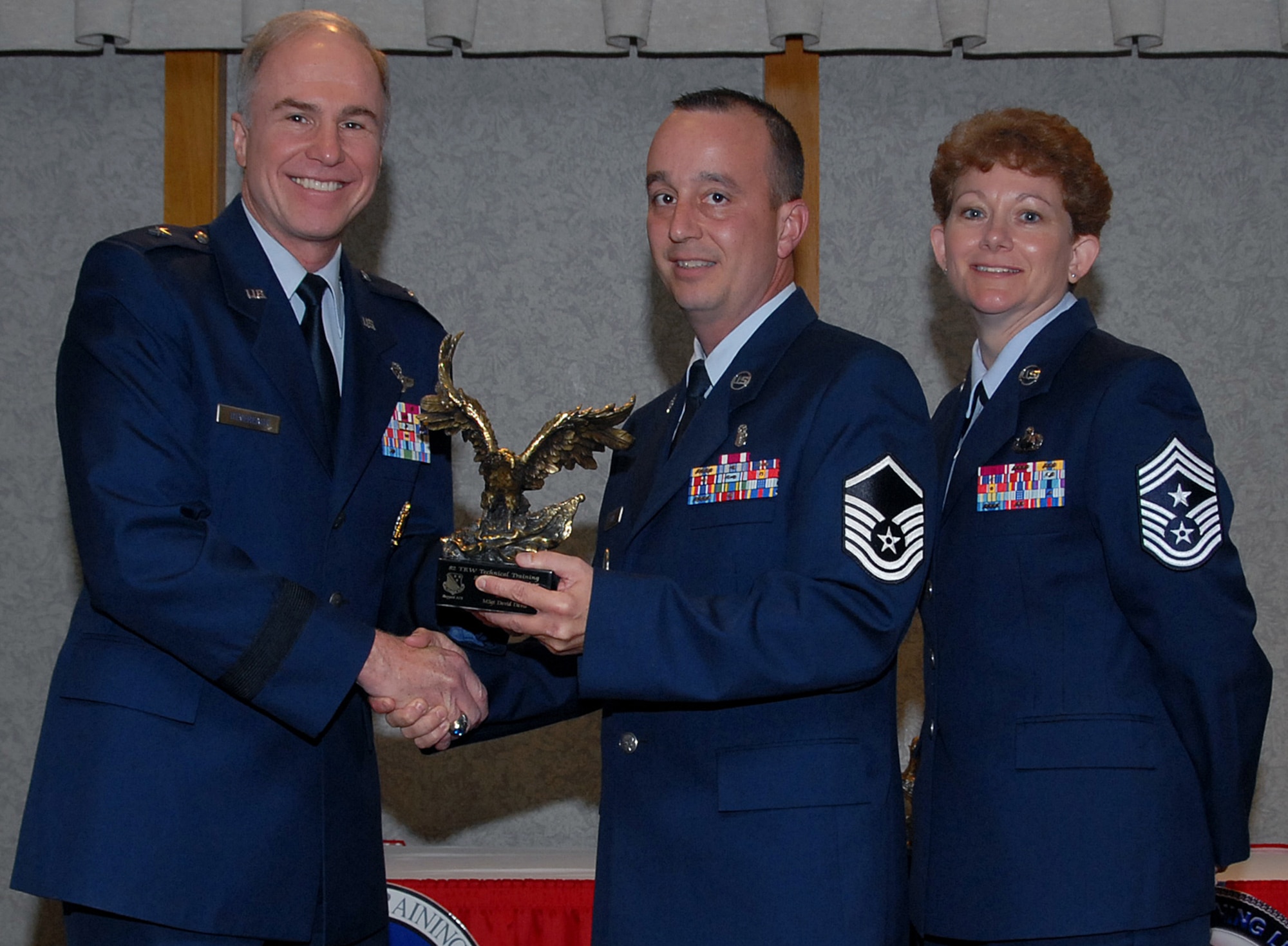 Master Sgt. David Davis of the 882nd Training Group accepts the 82nd Training Wing Senior NCO Instructor of the Year award March 19 from 82nd TRW Commander Brig. Gen. Richard Devereaux and 82nd TRW Command Chief Chief Master Sgt. Jeannie McLean.  Sergeant Davis was honored for his accomplishments as the Chief Master Sgt. Lewis W. Dunlap Mental Health Senior NCO Technician of the Year. He also created realistic Air Expeditionary Force scenarios that increased the war skills knowledge for Airmen and coordinated an Air Force Sergeants' Association food drive for the squadron, yielding 1,500 pounds of food for the food bank. (U.S. Air Force photo/Mike Litteken)
