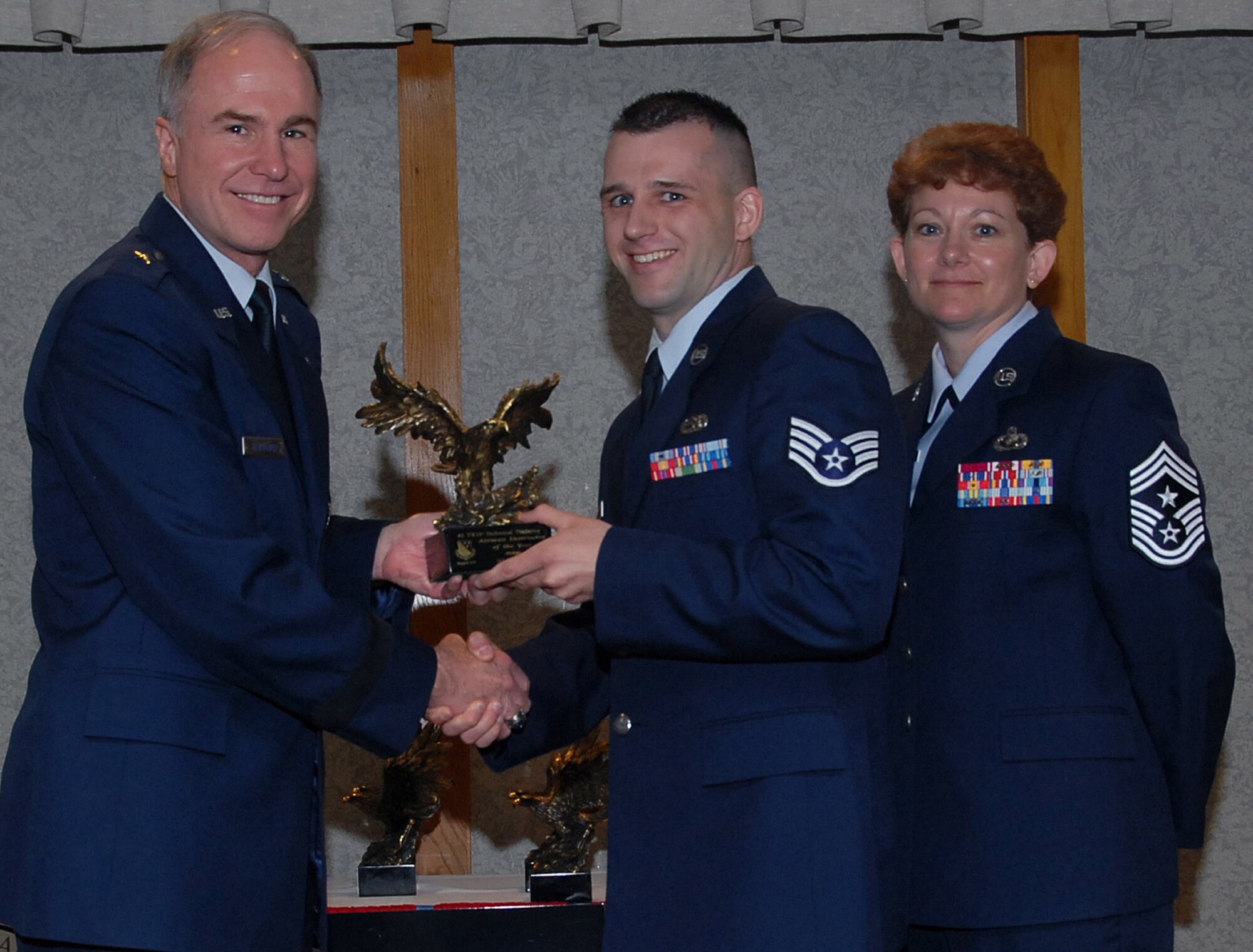 Staff Sgt. David Bard of the 82nd Training Group accepts the 82nd Training Wing Airman Instructor of the Year award March 19 from 82nd TRW Commander Brig. Gen. Richard Devereaux and 82nd TRW Command Chief Chief Master Sgt. Jeannie McLean. Sergeant Bard managed the Combat Ammunition System database for 37 instructor accounts, briefed maintenance officers on munititons assembly and handling procedures and was the John L. Levitow Award winner for his Airman Leadership School class. (U.S. Air Force photo/Mike Litteken)