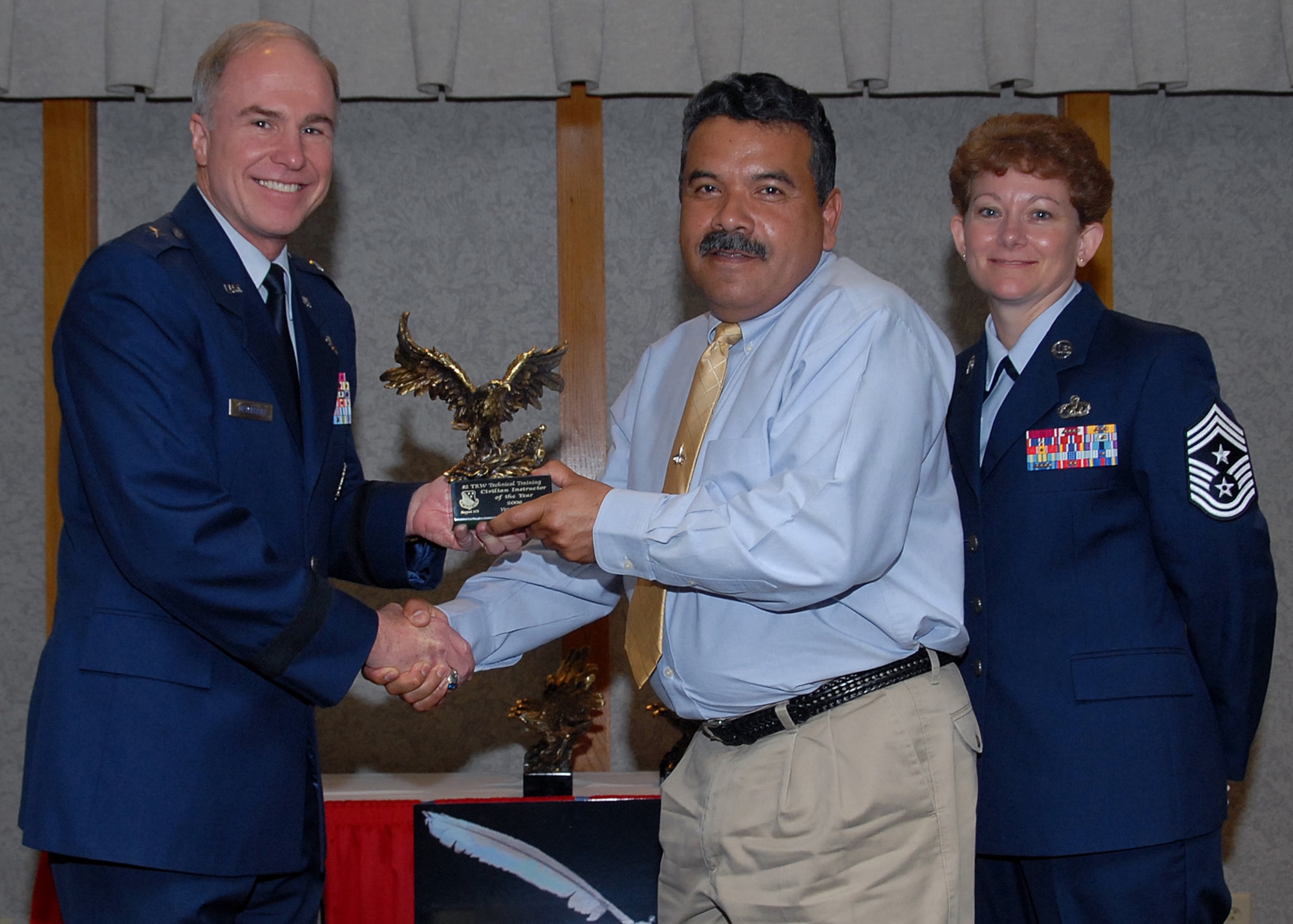 Victor Maduro of the 82nd Training Group accepts the 82nd Training Wing Civilian instructor of the Year award March 19 from 82nd TRW Commander Brig. Gen. Richard Devereaux and 82nd TRW Command Chief Chief Master Sergeant Jeannie McLean.  Mr. Maduro's accomplishments included briefing a safety program to the Air Education and Training Command Inspector General, authored a new jet engine course for F-100 engines and supported the Sheppard Womens' History program by raising money toward educational projects. (U.S. Air Force photo/Mike Litteken)