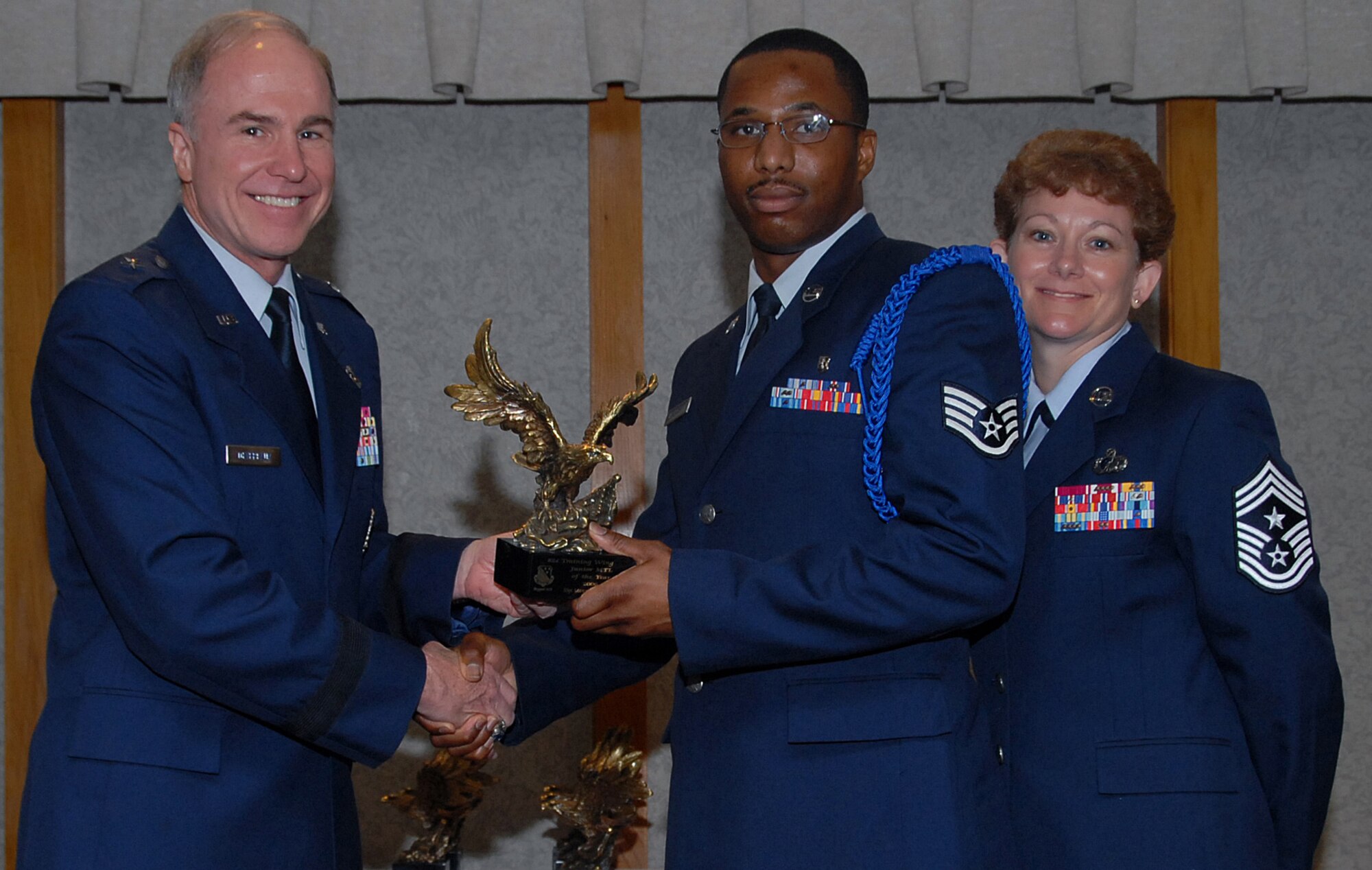 Staff Sgt. Marcus Washington of the 82nd Training Wing accepts the 82nd TRW Junior Military Training Leader of the Year award March 19 from 82nd TRW Commander Brig. Gen. Richard Devereaux and 82nd TRW Command Chief Chief Master Sgt. Jeannie McLean.  Sergeant Washington trained more than 1,000 enlisted members, officers, Airmen, Soldiers and Marines for five parades, managed the Airmen Leader program for 10 squadrons, training 500 future leaders and coached the Top of Texas youth football team. (U.S. Air Force photo/Mike Litteken)