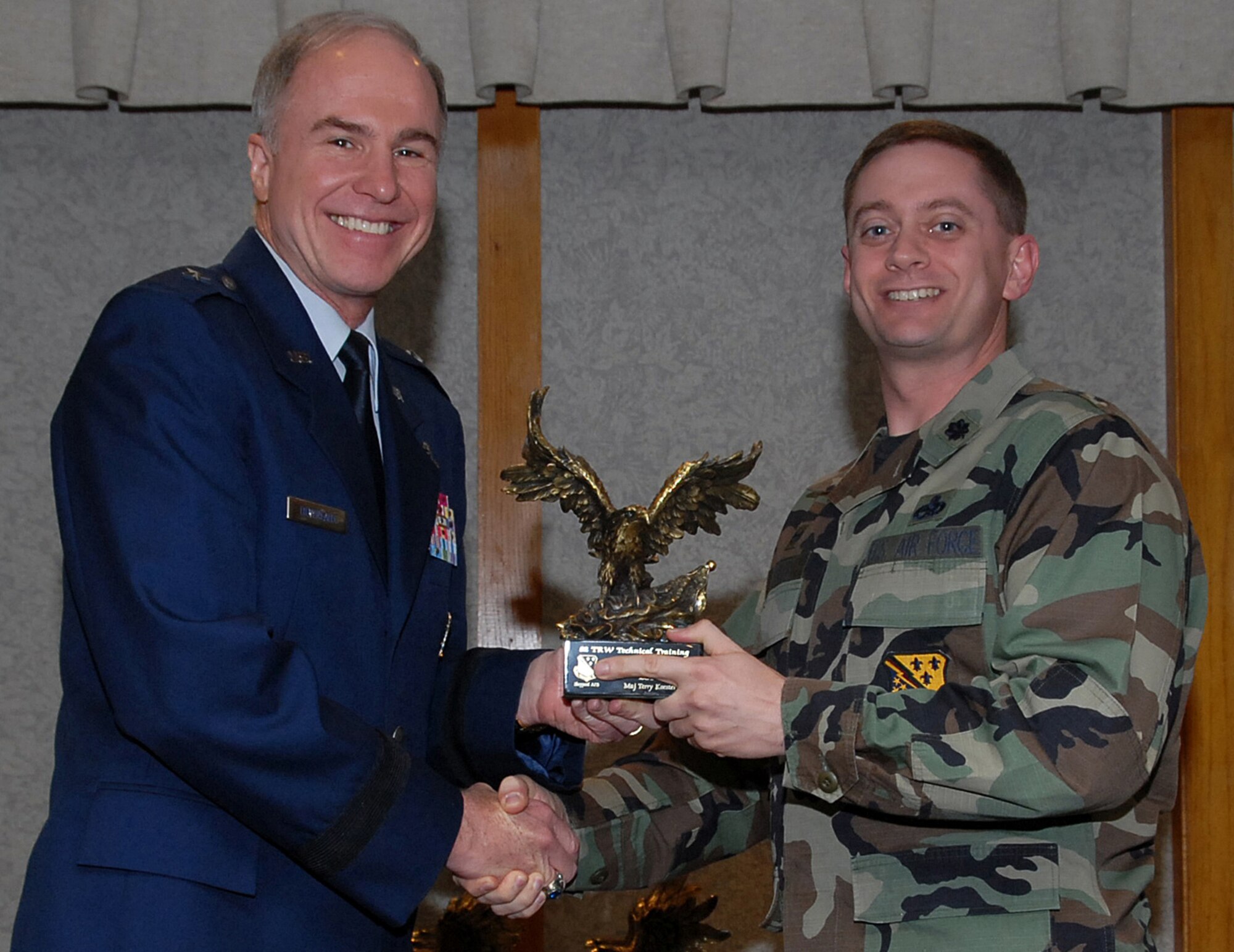 Lt. Col. Glenn Roberts, commander of the 360th Training Squadron, accepts the 82nd Training Wing Support Officer of the Year award March 19 on behalf of Maj. Terry Koester from 82nd TRW Commander Brig. Gen. Richard Devereaux.  Major Koester was the catalyst behind his squadron's selection as the wing nominee for the Hoyt S. Vandenberg Award. Major Koester was the 82nd Training Group person of contact for the Holiday Exodus and was a Christmas in Action volunteer that led six teams in repairing six homes for the elderly. (U.S. Air Force photo/Mike Litteken)