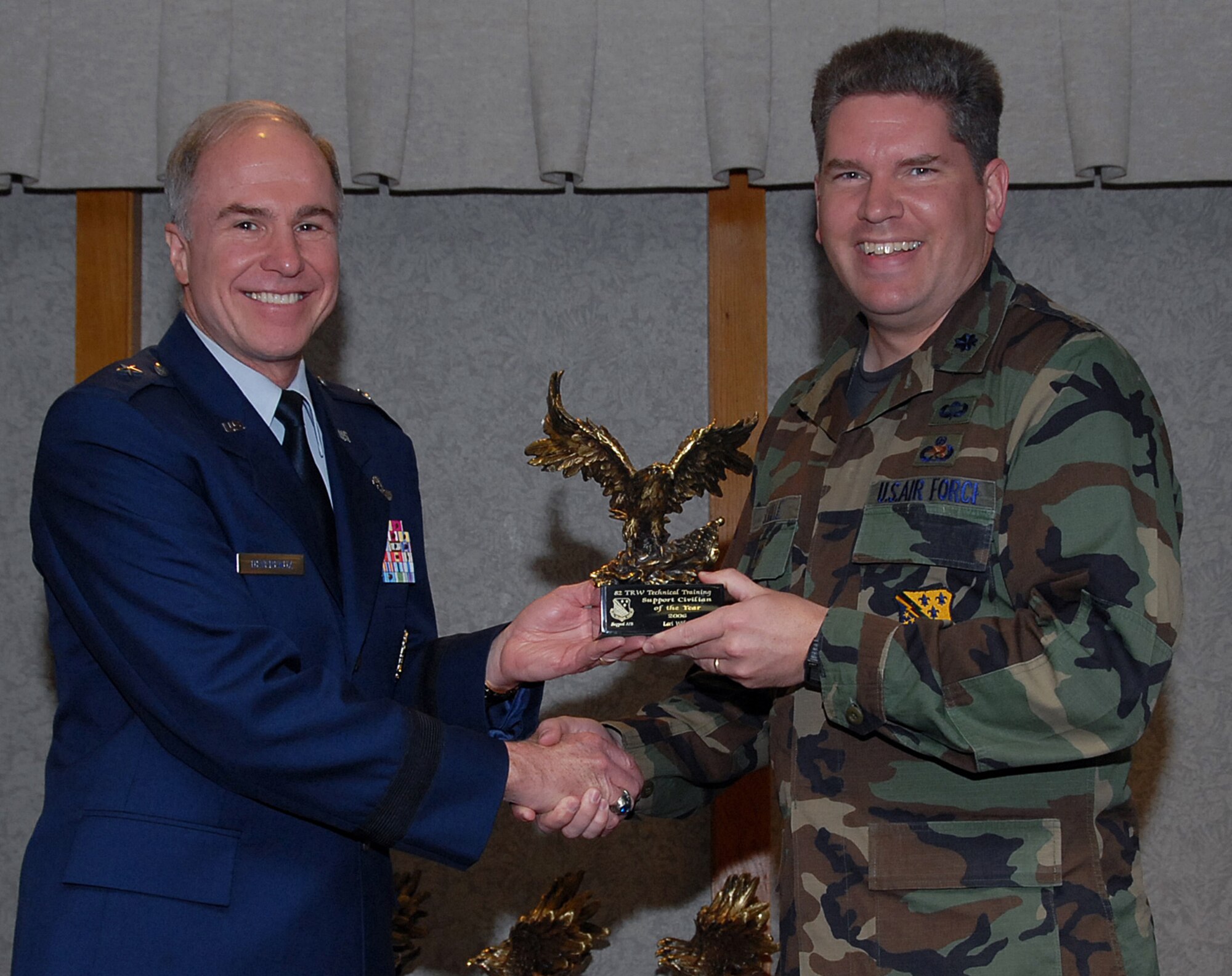 Lt. Col. David Saville, deputy commander of the 82nd Training Group, accepts the 82nd Training Wing Support Civilian of the Year award March 19 from 82nd TRW Commander Brig. Gen. Richard Devereaux on behalf of Lori Wilson.  Ms. Wilson authored two Operational Readiness Inspection validated "Air Force Best Practices," was handpicked by the Air Education Training Command Inspector General's office to augment them for the Lackland Air Force Base, Texas, ORI and trained nine inspectors for the group Maintenance Standardization Evaluation Program. (U.S. Air Force photo/Mike Litteken)