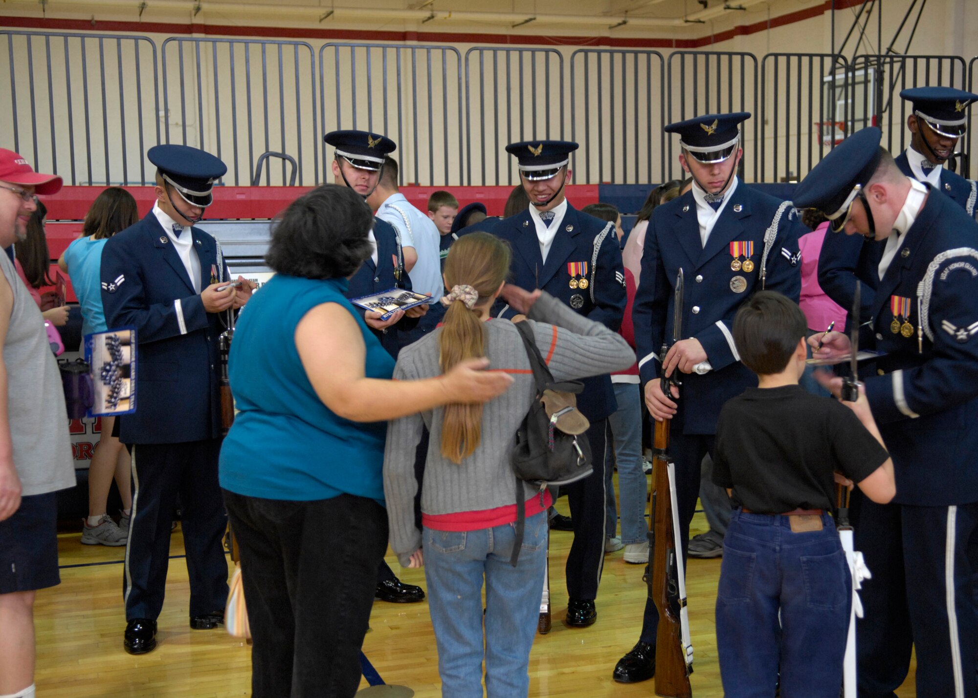 The United States Air Force Honor Guard Drill Team autographs AF recruiting posters, after their performance, at the East Fitness Center on Kirtland Air Force Base, N.M., March 15, 2007. The Drill Team is the traveling component of the Air Force Honor Guard and tours Air Force bases world wide showcasing the precision of today's Air Force to recruit, retain, and inspire Airmen for the Air Force mission. (U.S. Air Force photo by Airman 1st Class Rusti Caraker)(Released)
