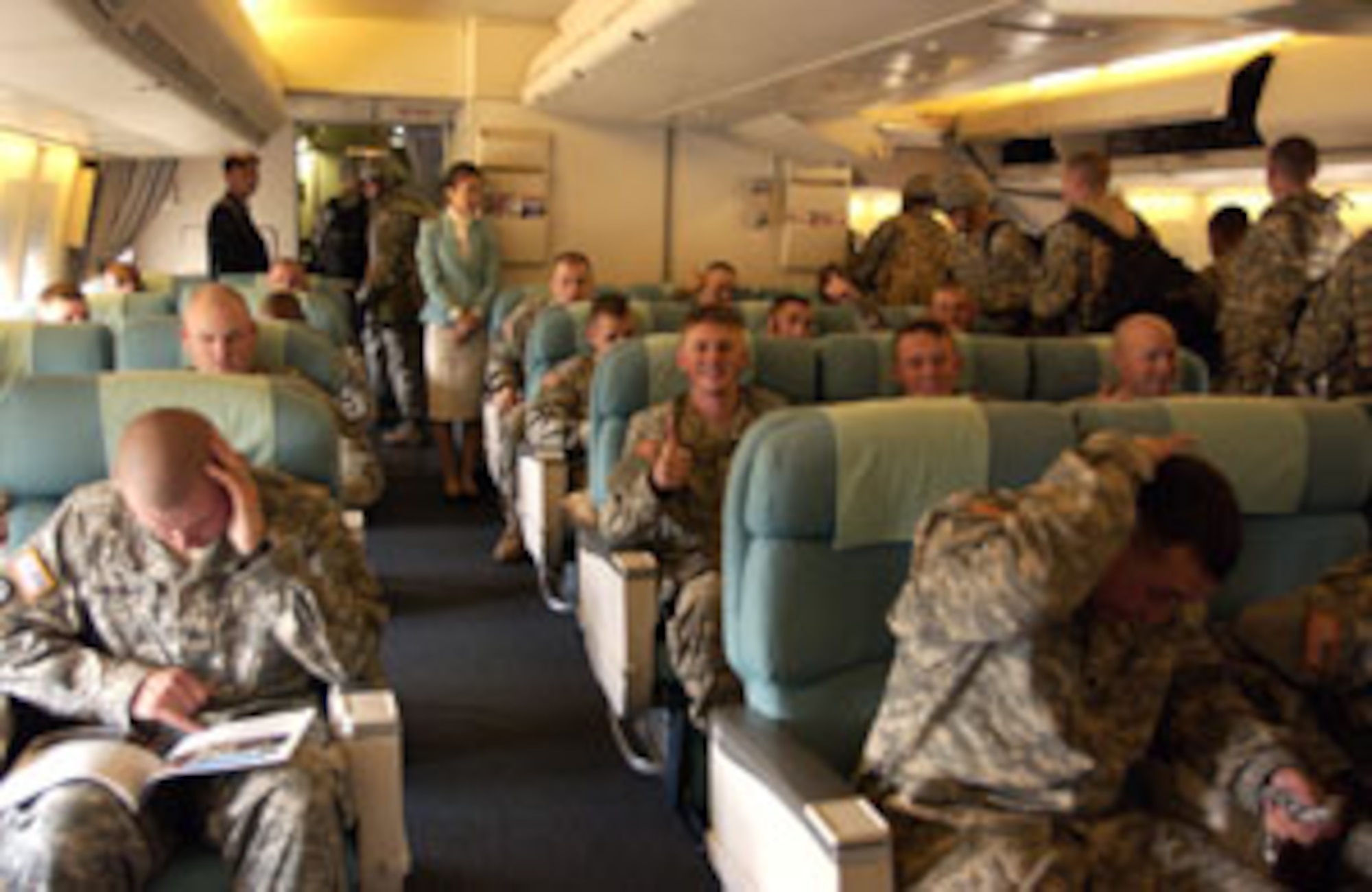 Soldiers from Fort Irwin, Calif., get comfortable on a Korean Air  747 before it departs March Air Reserve Base, Calif.  The aircraft landed Wednesday at March ARB to pick up passengers making it the first time a Korean airlines aircraft physically has been exercised as part of the 26 year Mutual Airlift Support Agreement between the Department of Defense and the South Korean Air Force.  (U.S. Air Force photo by Staff Sgt. Amy Abbott, 452 AMW/PA)                            
