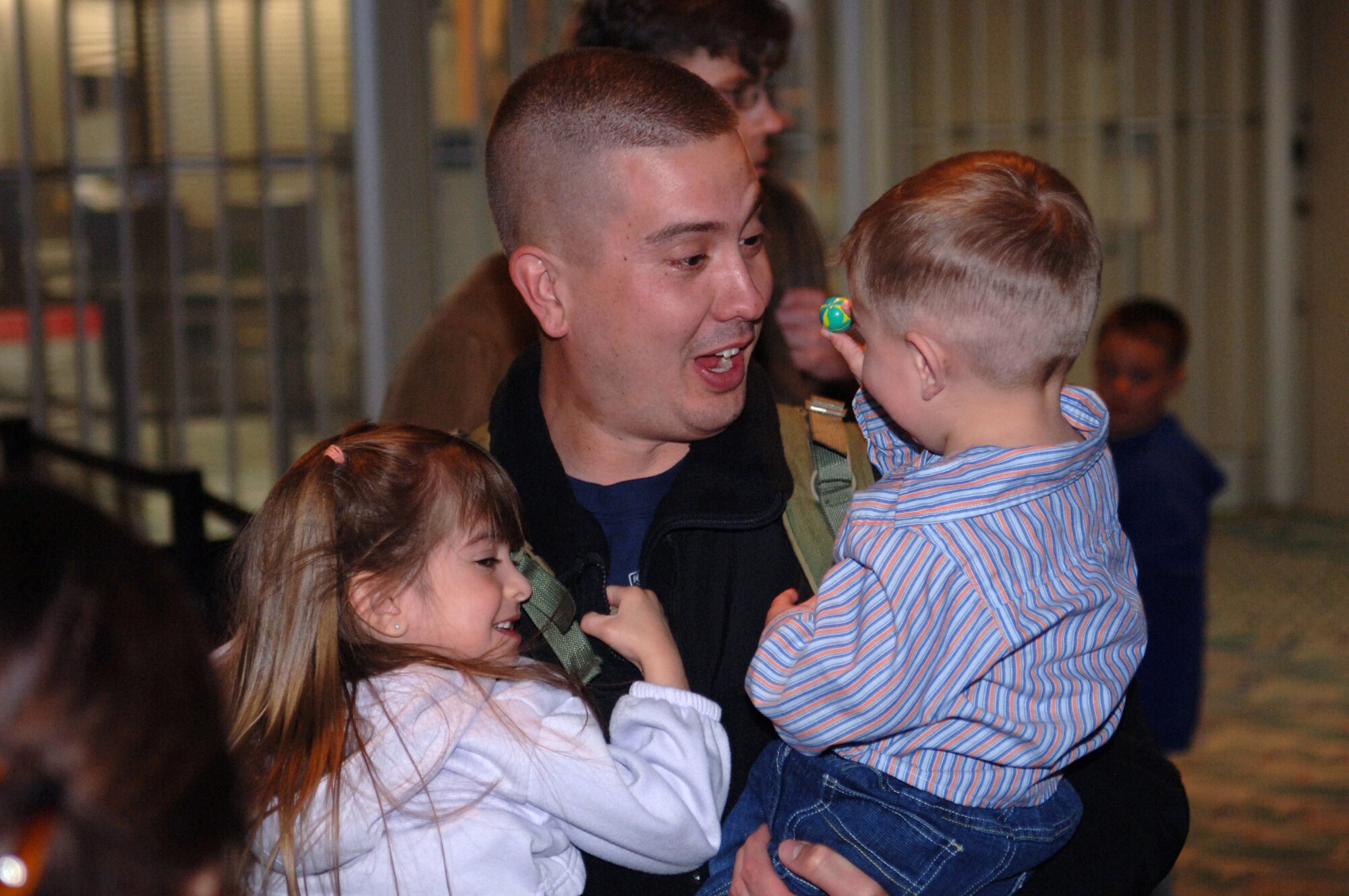 Staff Sgt. Paul Flanagan holds his children, Maghan and Braden, upon arriving at the Rapid City Regional Airport March 21. Sergeant Flanagan, assigned to the 28th Security Forces Squadron, returned from a deployment to Southwest Asia in support of operations Iraqi Freedom and Enduring Freedom. (U.S. Air Force photo/Airman 1st Class Angela Ruiz)